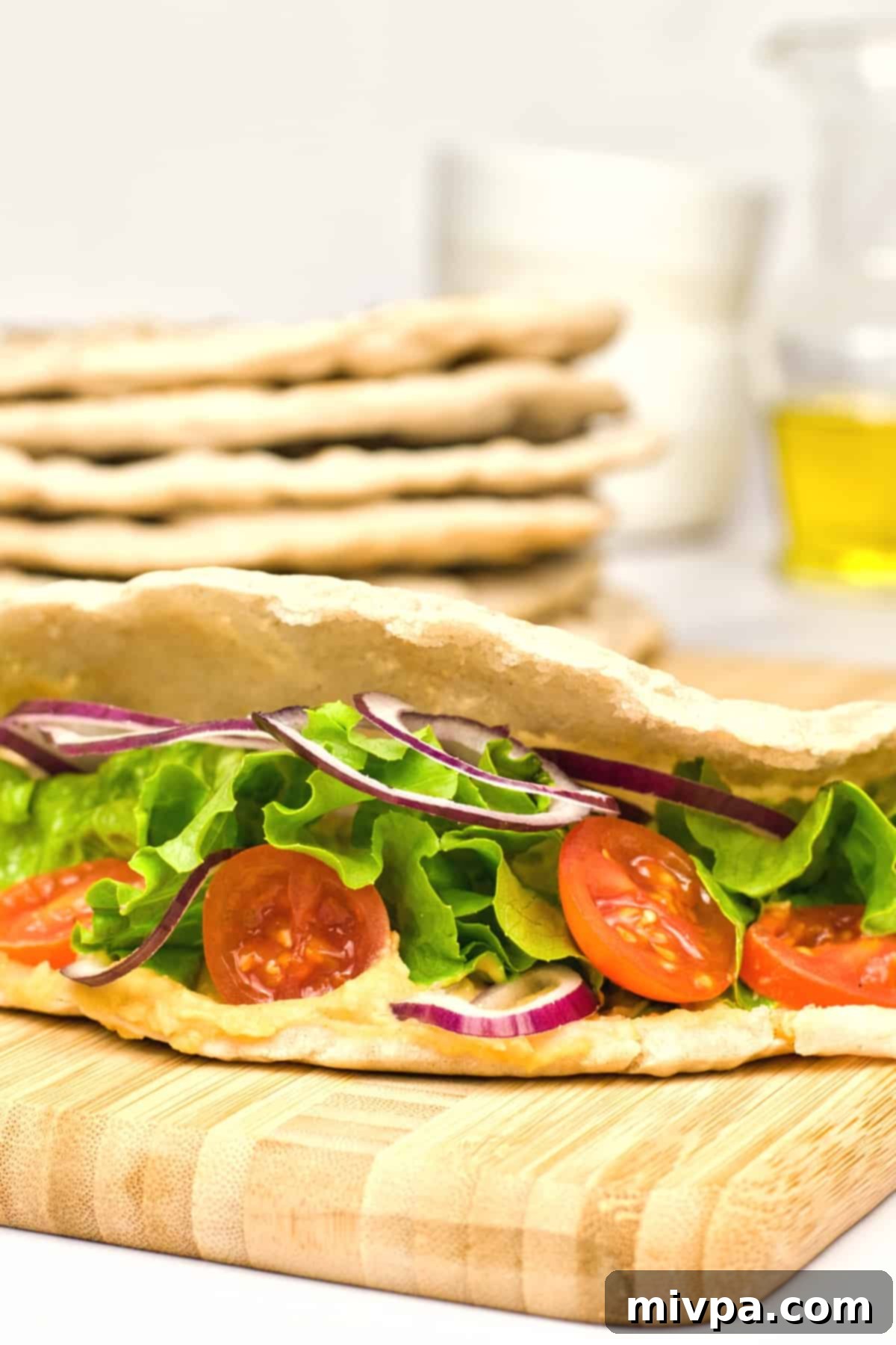 Gluten-Free Pita Bread Recipe (Dairy-Free, Vegan) A vibrant, fresh salad overflowing from a perfectly opened gluten-free pita bread pocket.