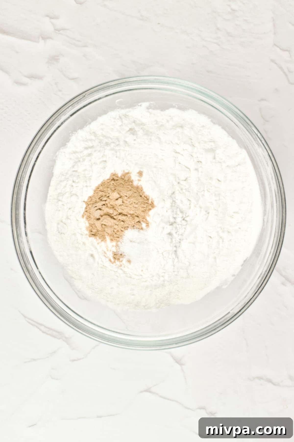 GF Pita Bread Recipe (vegan) A glass bowl containing a mix of gluten-free flour and psyllium husk powder.