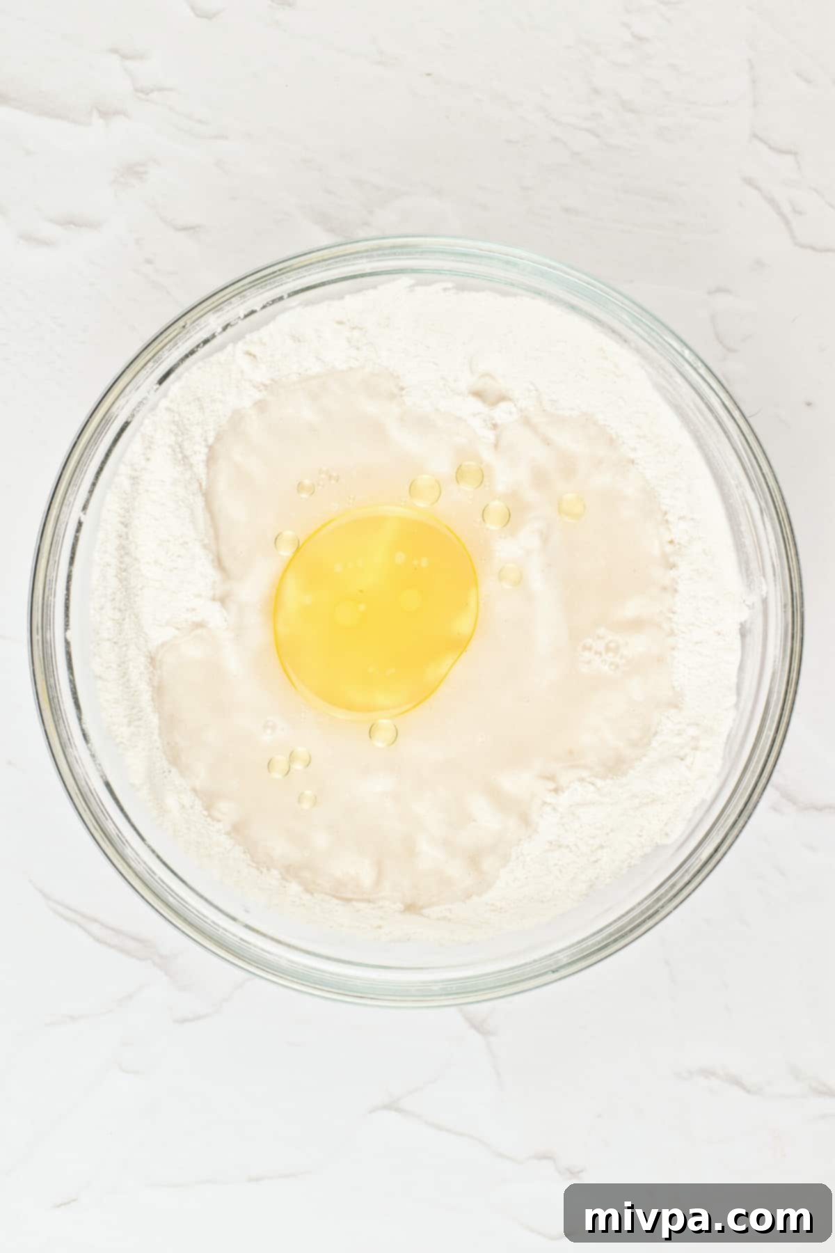 Gluten-Free Arabic Flatbread A bowl with dry ingredients, liquids, and oil starting to mix together to form dough.