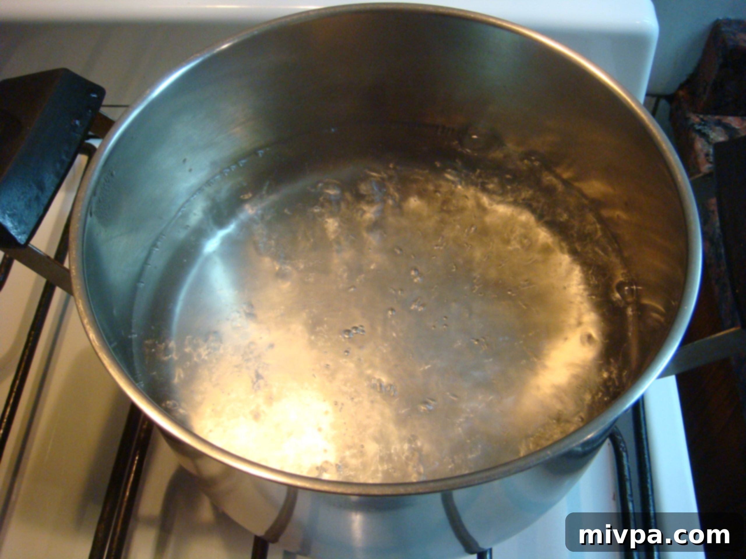 Boiling Water for Polenta A pot of water vigorously boiling on a stovetop, indicating it has reached the ideal temperature for adding polenta.