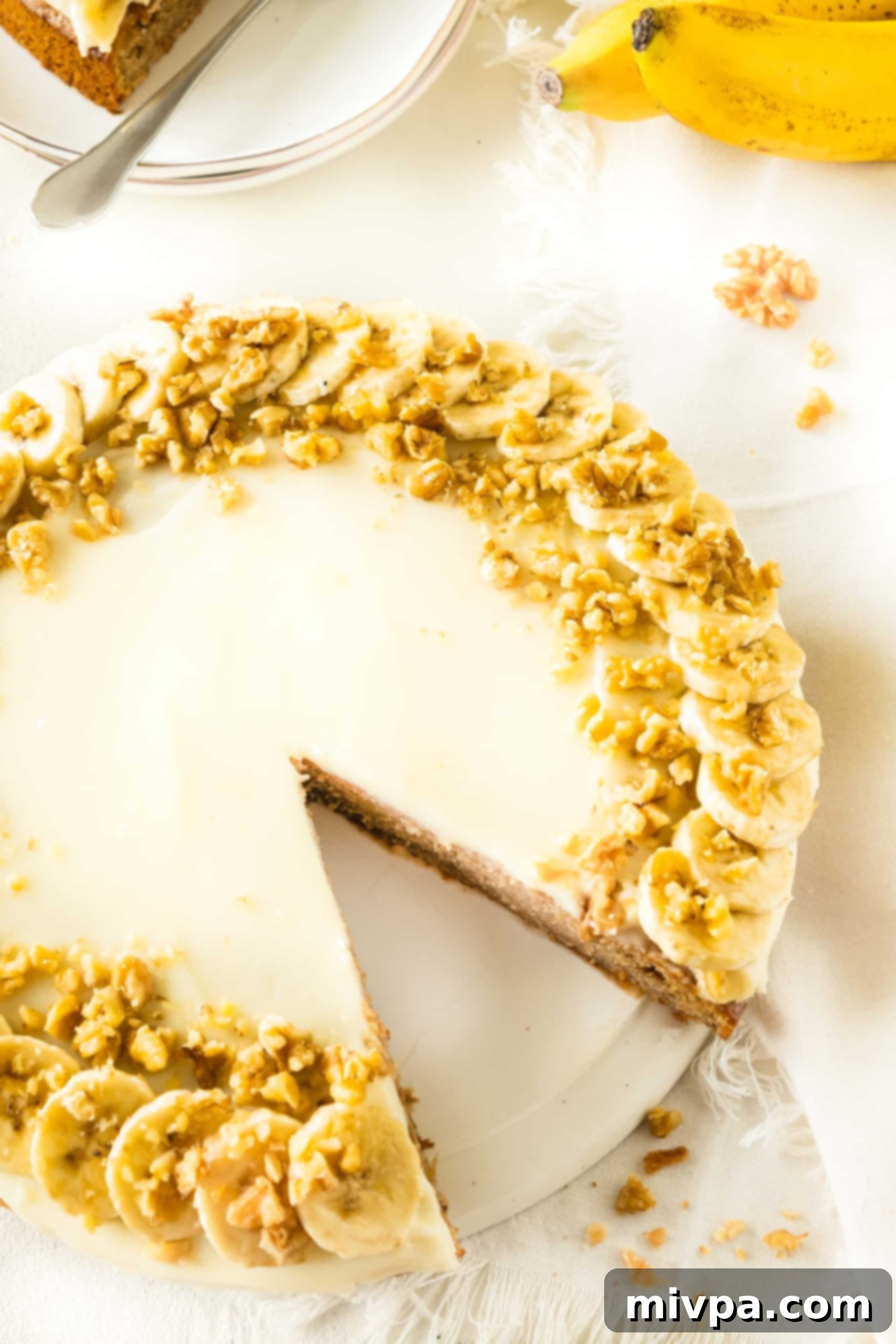 Banana Cake (Gluten-Free, Dairy-Free) Half-sliced gluten-free banana cake on cake stand.