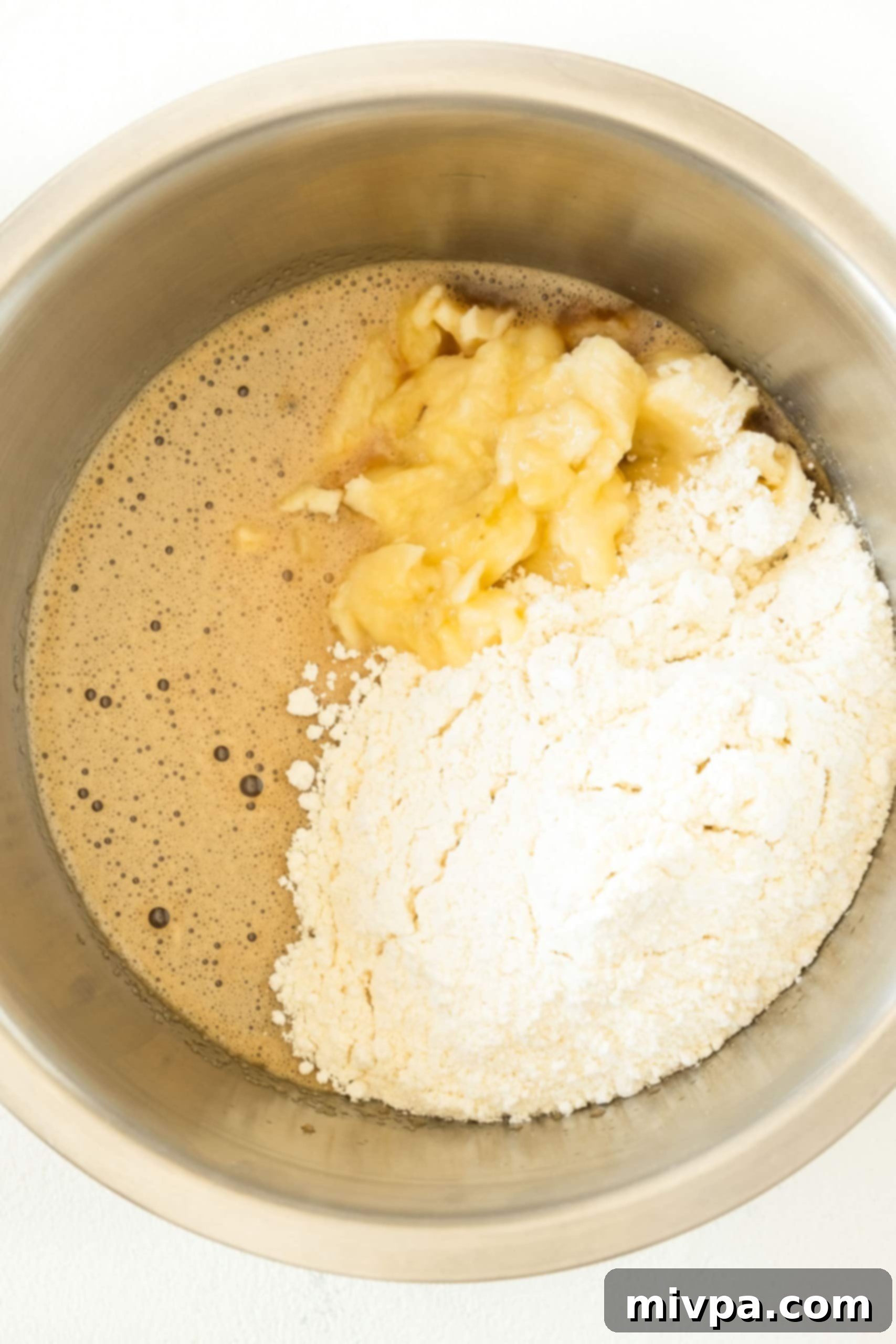 Easy Banana Cake Recipe (Gluten-Free, Dairy-Free) Ingredients for banana cake batter in a metal bowl.
