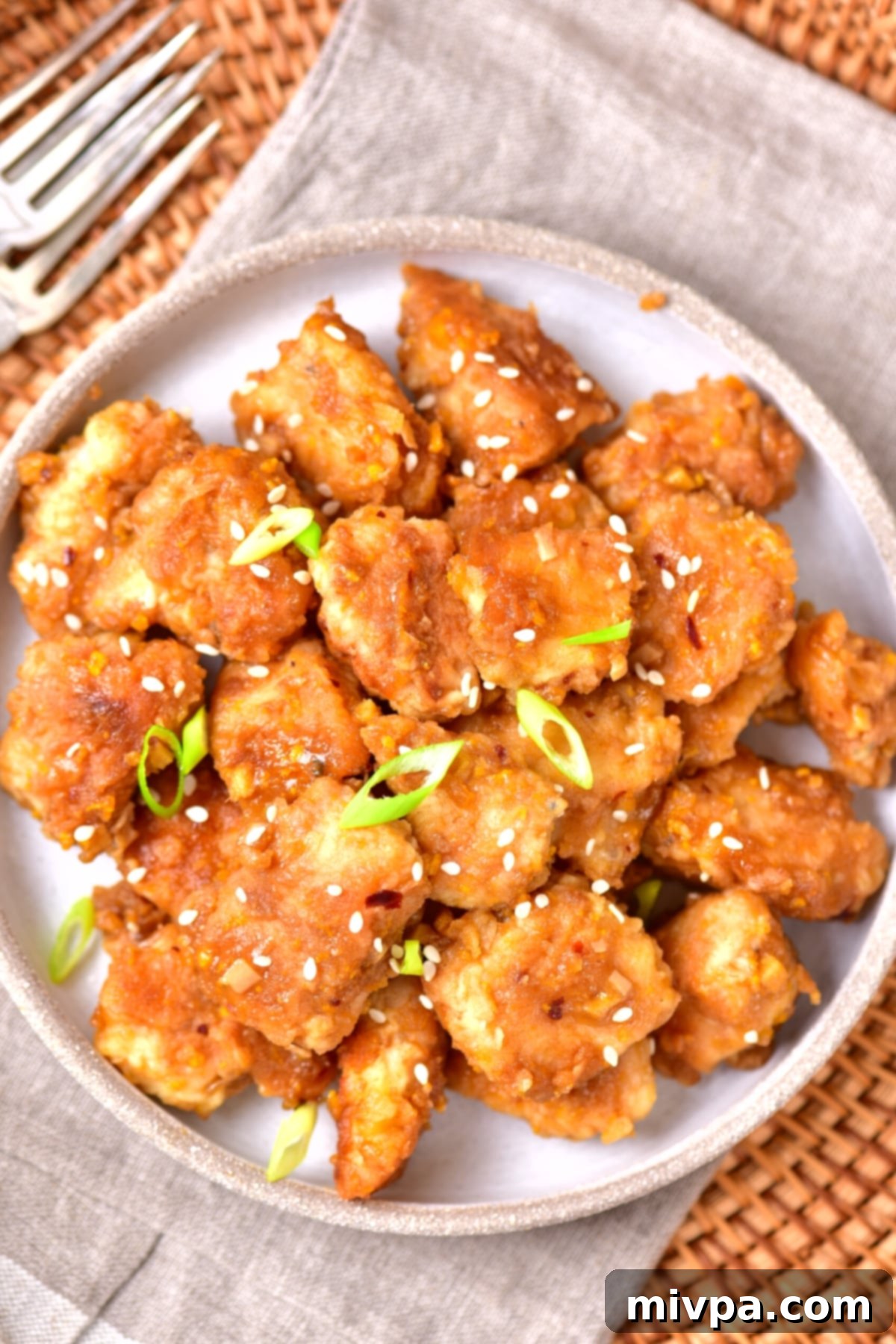 GF Orange Chicken Recipe A top-down, artfully arranged plate of gluten-free orange chicken, perfectly capturing its appetizing presentation.