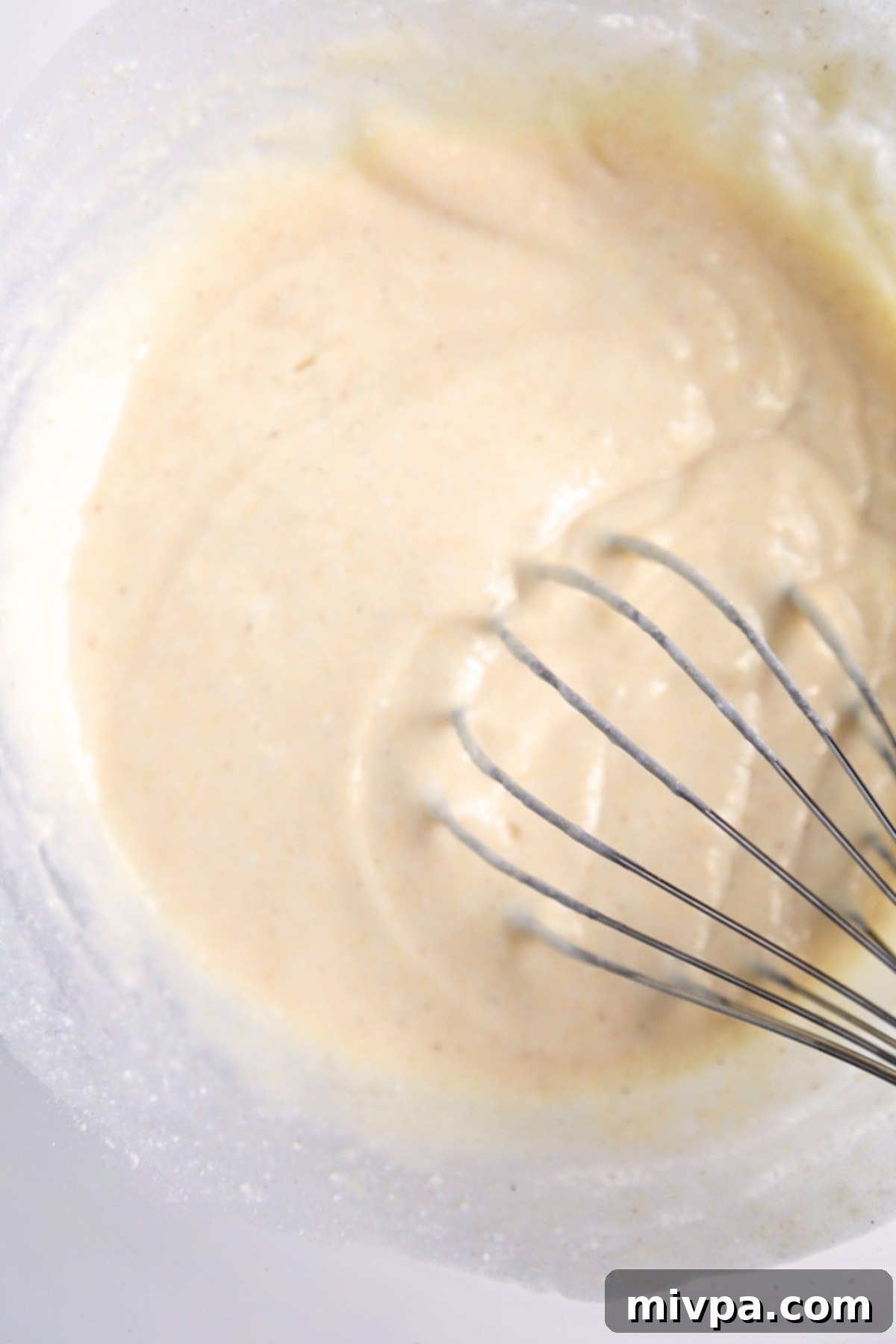 Whisking pancake batter in bowl.