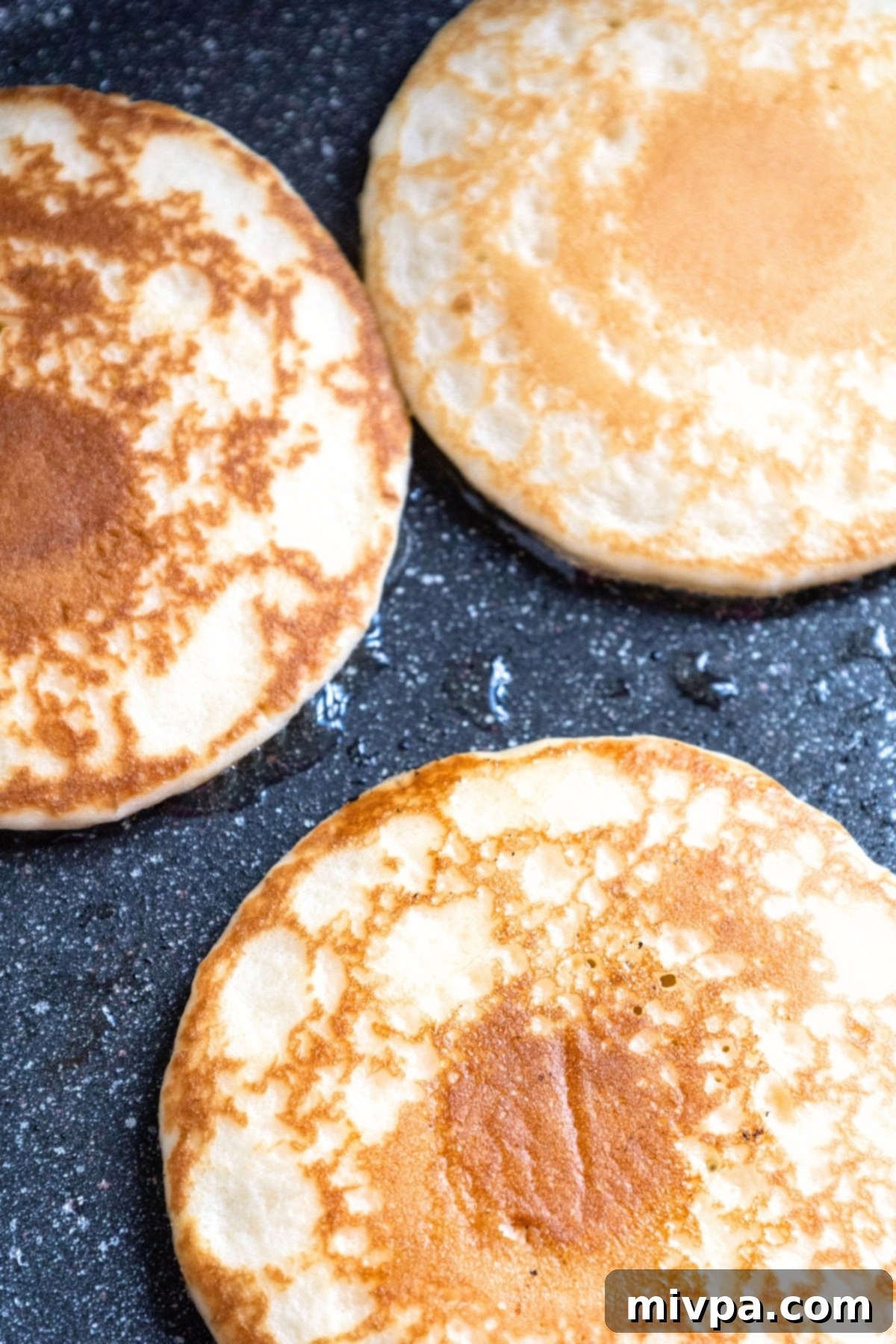 Cooking buttermilk pancakes in a skillet.