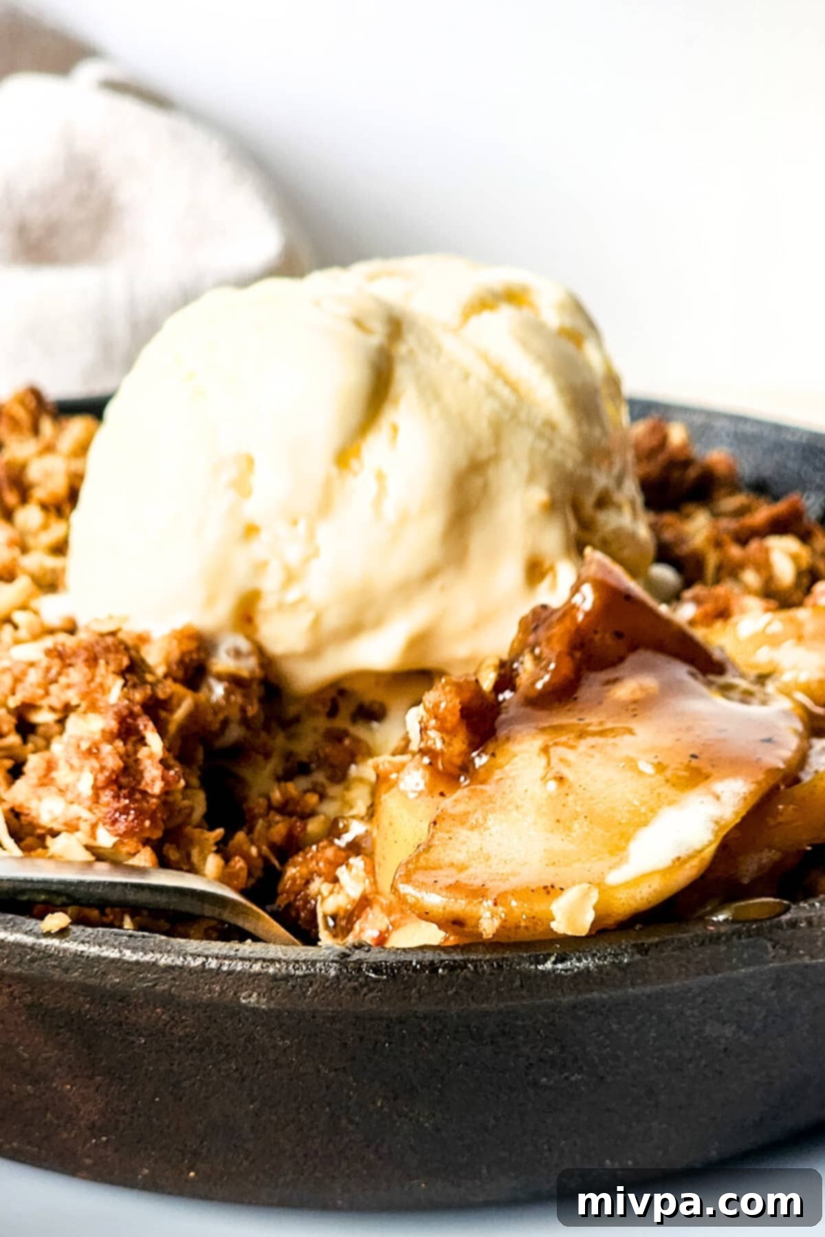 Up close shot of dairy-free apple crisp in a skillet, steam gently rising.