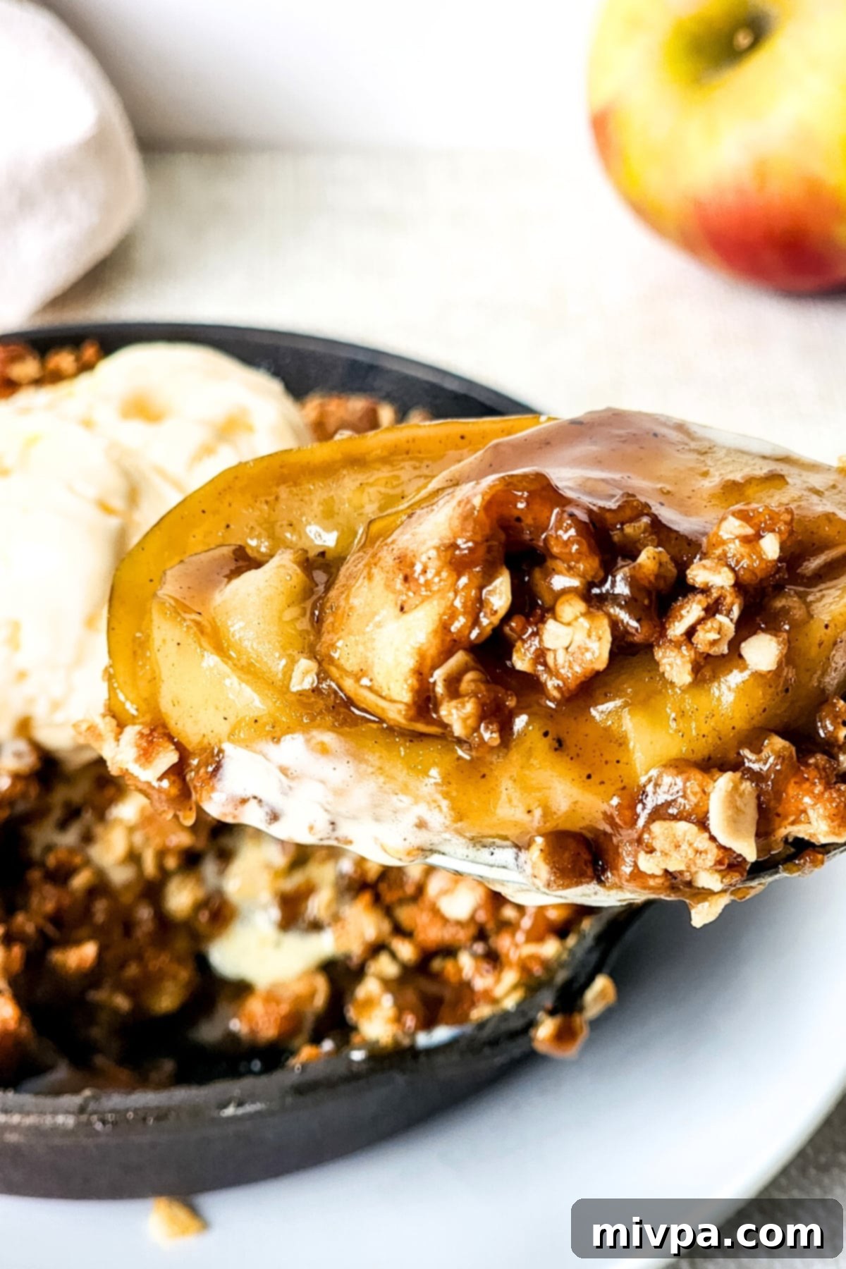Holding up a spoonful of gluten-free dairy-free apple crisp, showing the distinct layers.