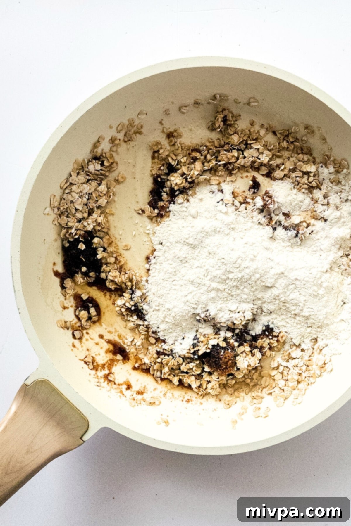 Flour mixture, oats, sugar, and melted dairy-free butter combined in a saucepan, forming a crumble.