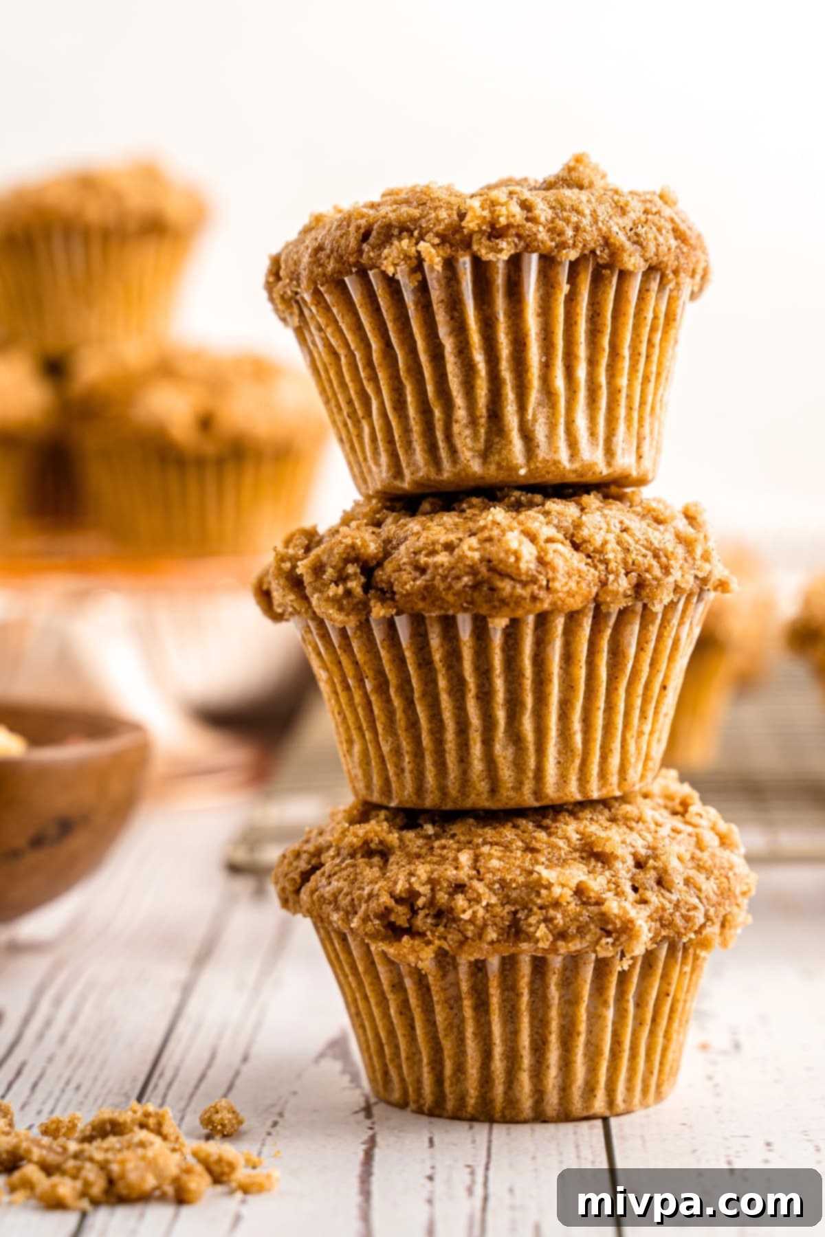 A stack of gluten-free applesauce muffins on wooden board.
