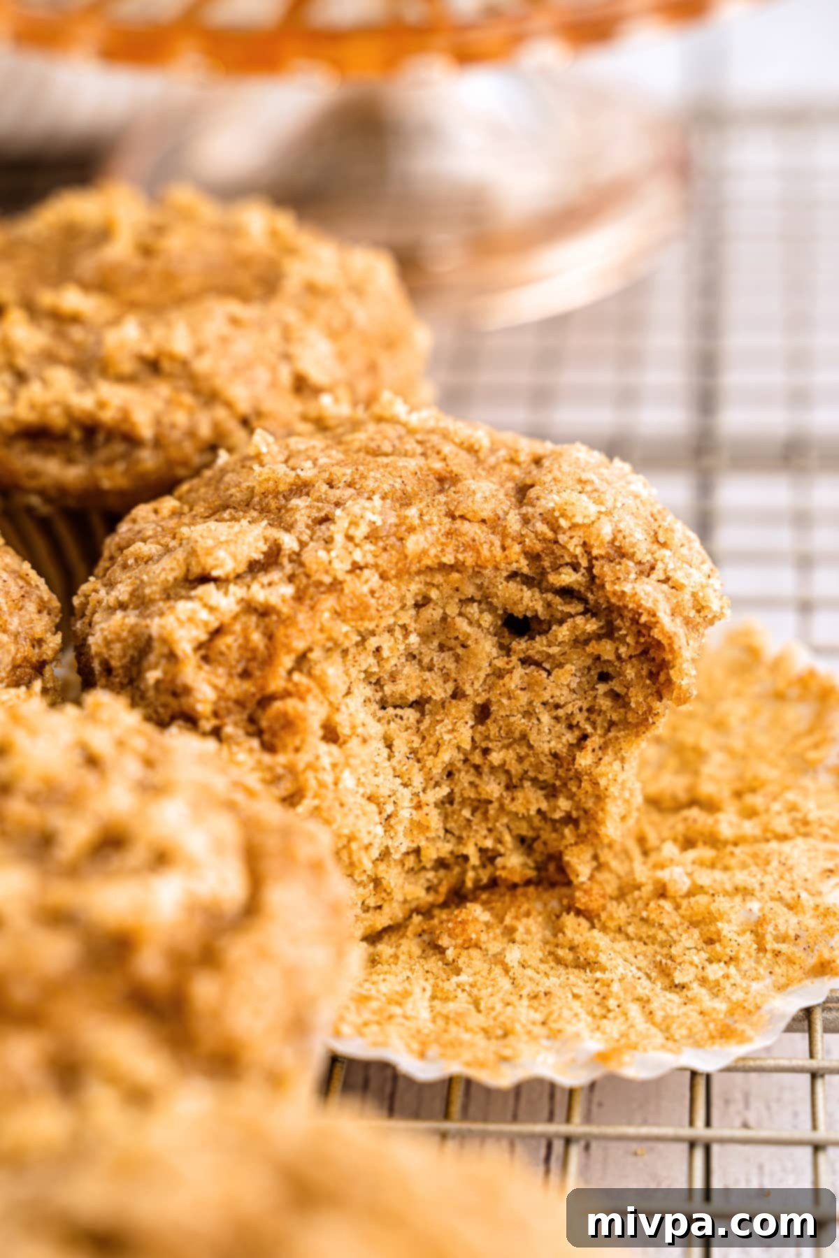 Half eaten applesauce muffins on wire rack.
