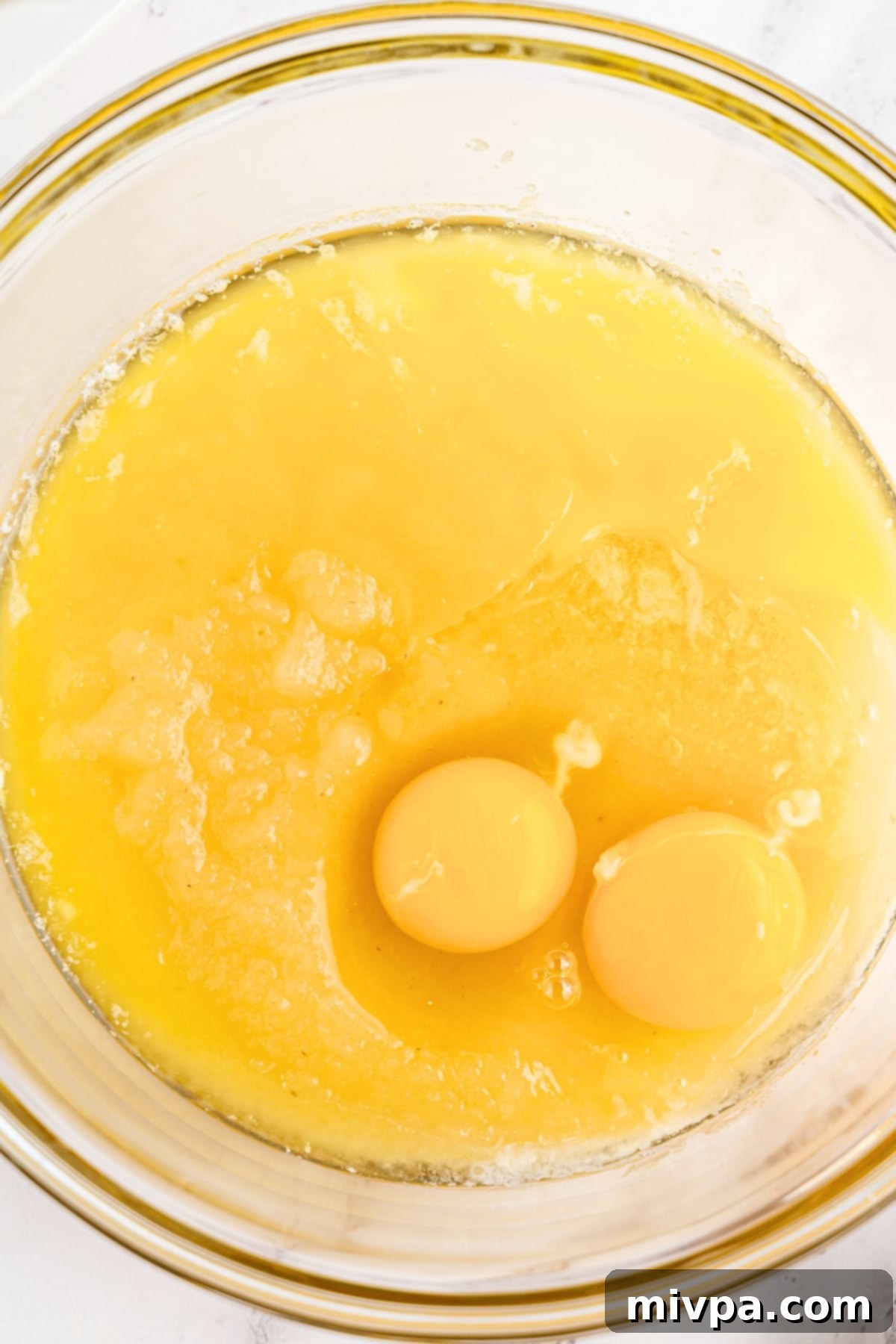 Yellow mixture with eggs in glass bowl