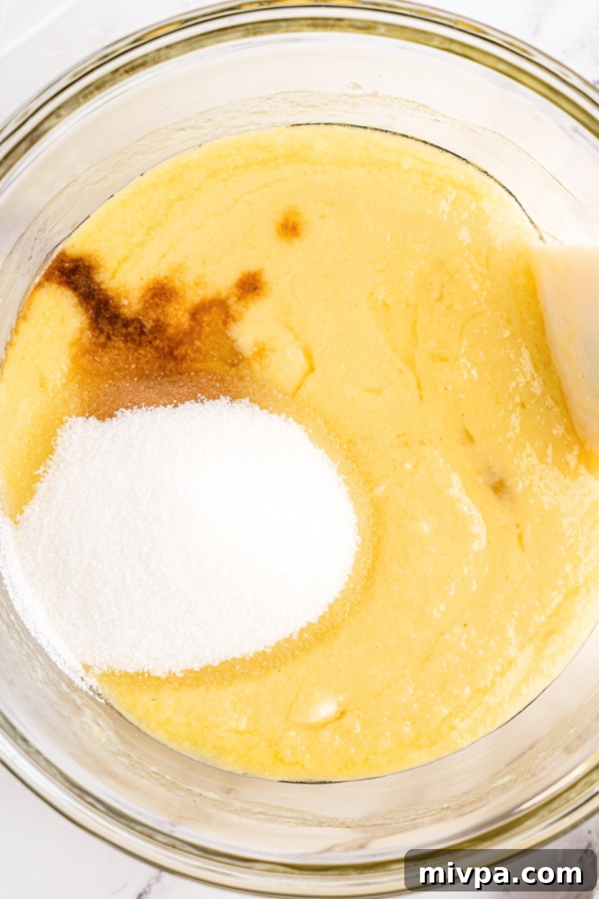 Mixing muffin batter in glass bowl.