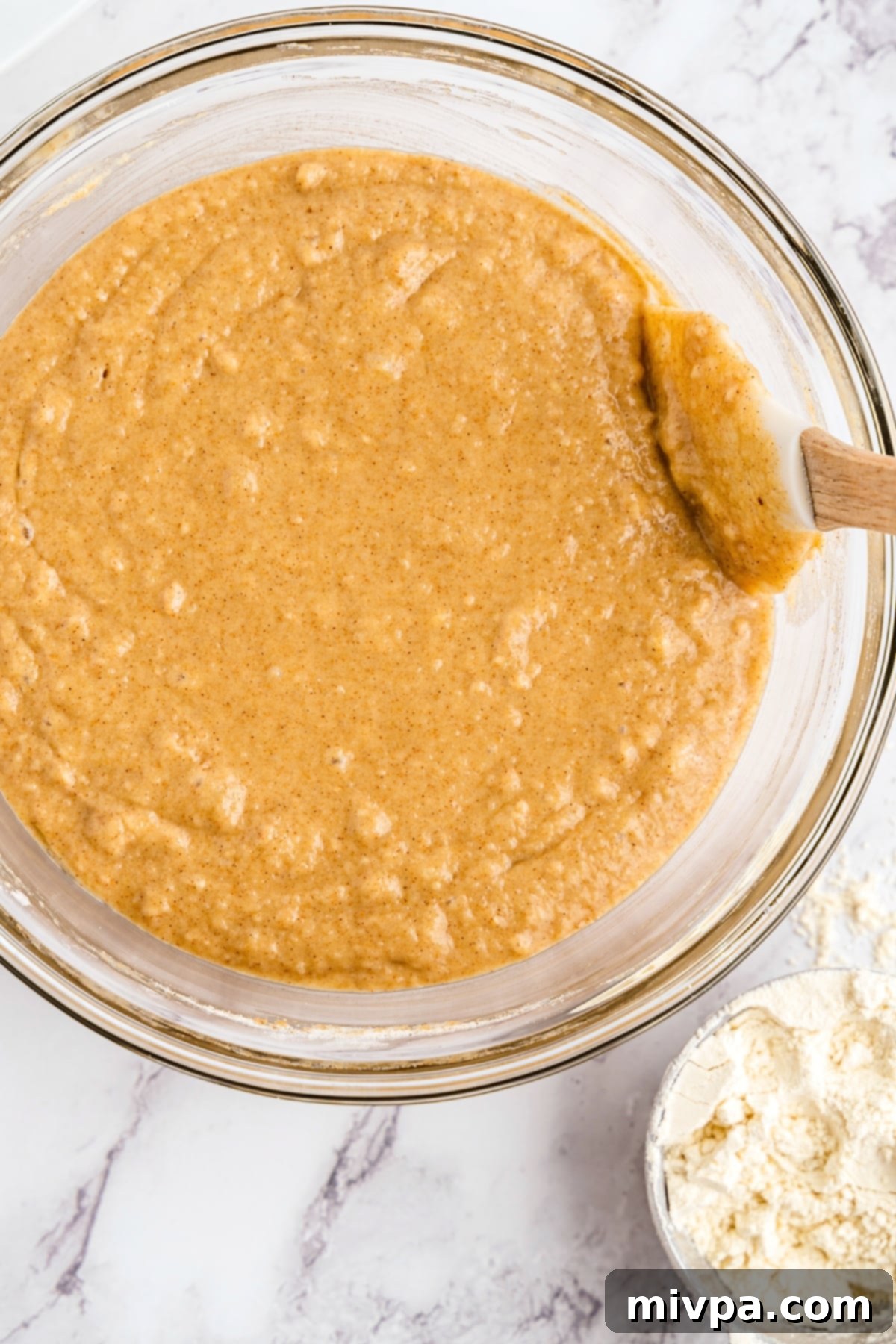 Mixing muffin batter in glass bowl.