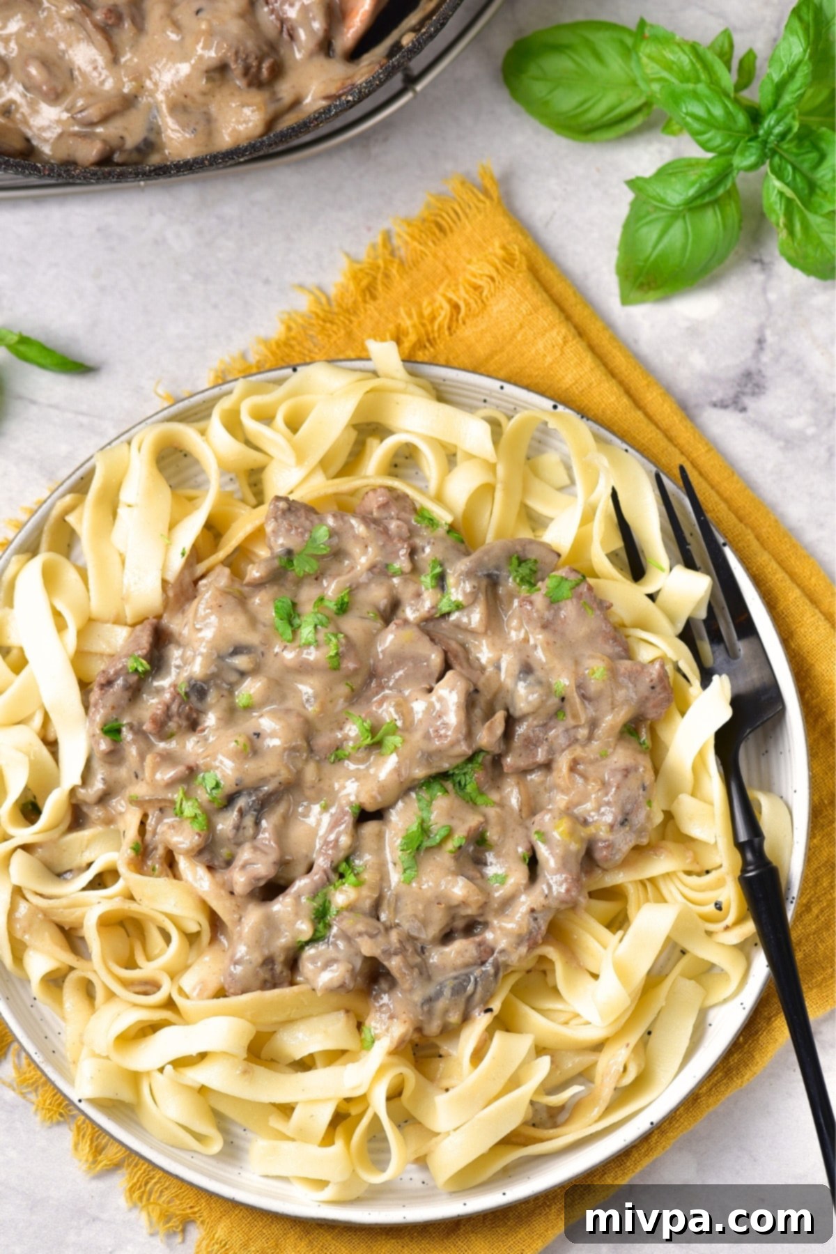 Gluten-Free Stroganoff (Dairy-Free) Top down view of a plate of gluten-free stroganoff on yellow towel.