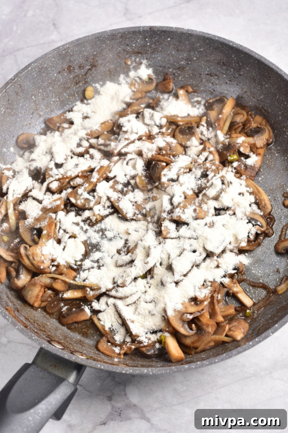 Beef Stroganoff (Gluten-Free) Flour sprinkled over sautéed mushrooms