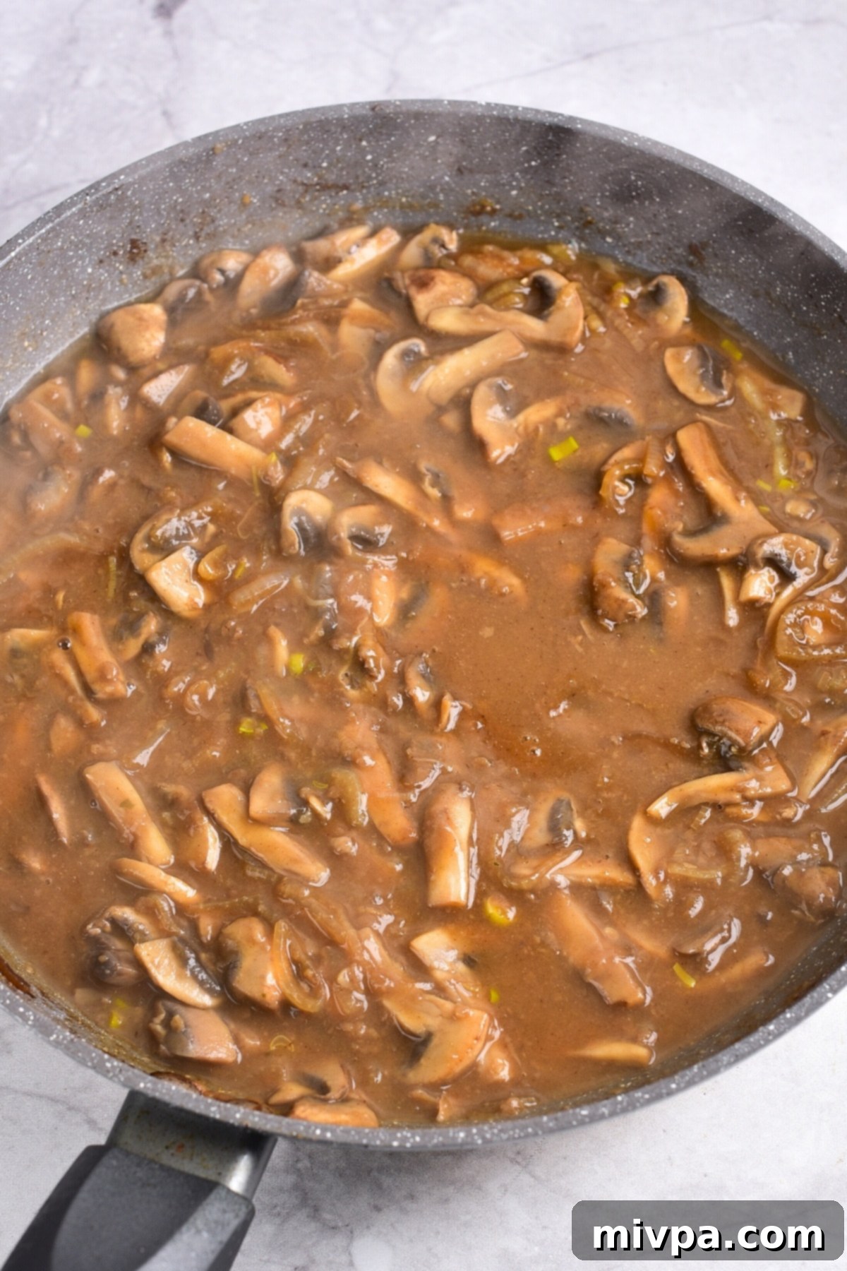 Gluten-Free Beef Stroganoff (Dairy-Free) Cooking gluten-free beef stroganoff sauce in skillet.