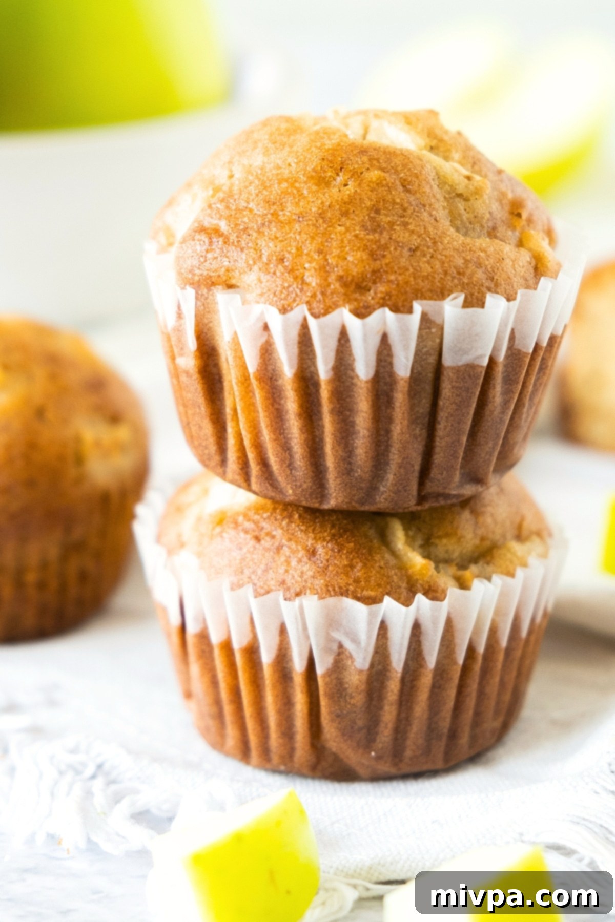 A beautifully arranged stack of tender gluten-free apple muffins, highlighting their moist texture.