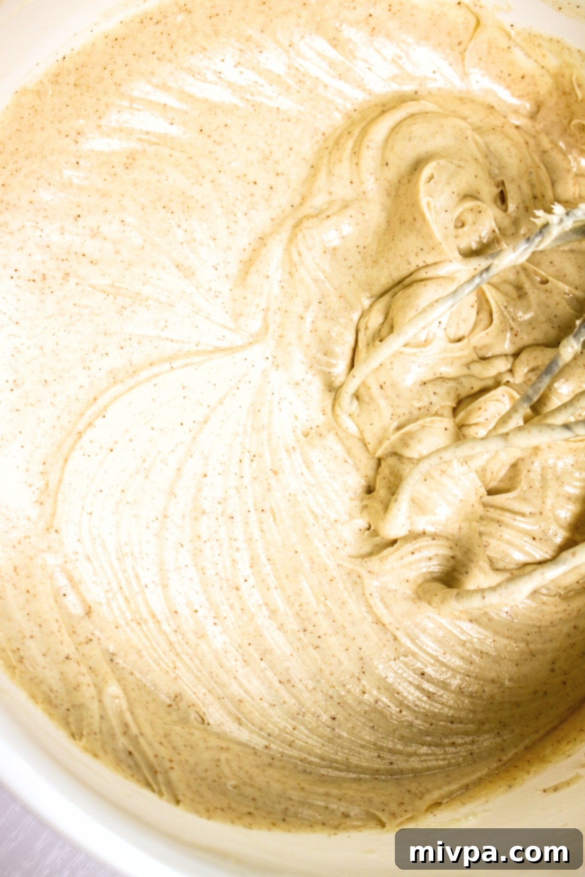 Smooth cinnamon cream cheese frosting in a mixing bowl.