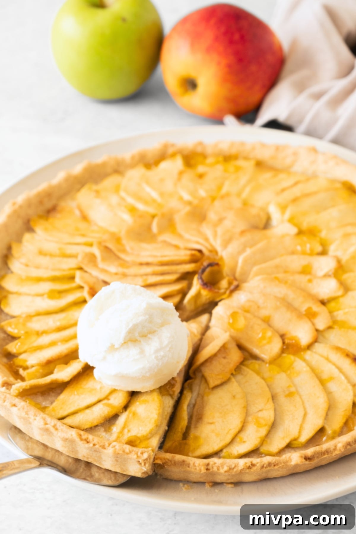 Gluten-Free Apple Tart (Dairy-Free) Reaching for a slice of gluten-free apple tart topped with ice cream.