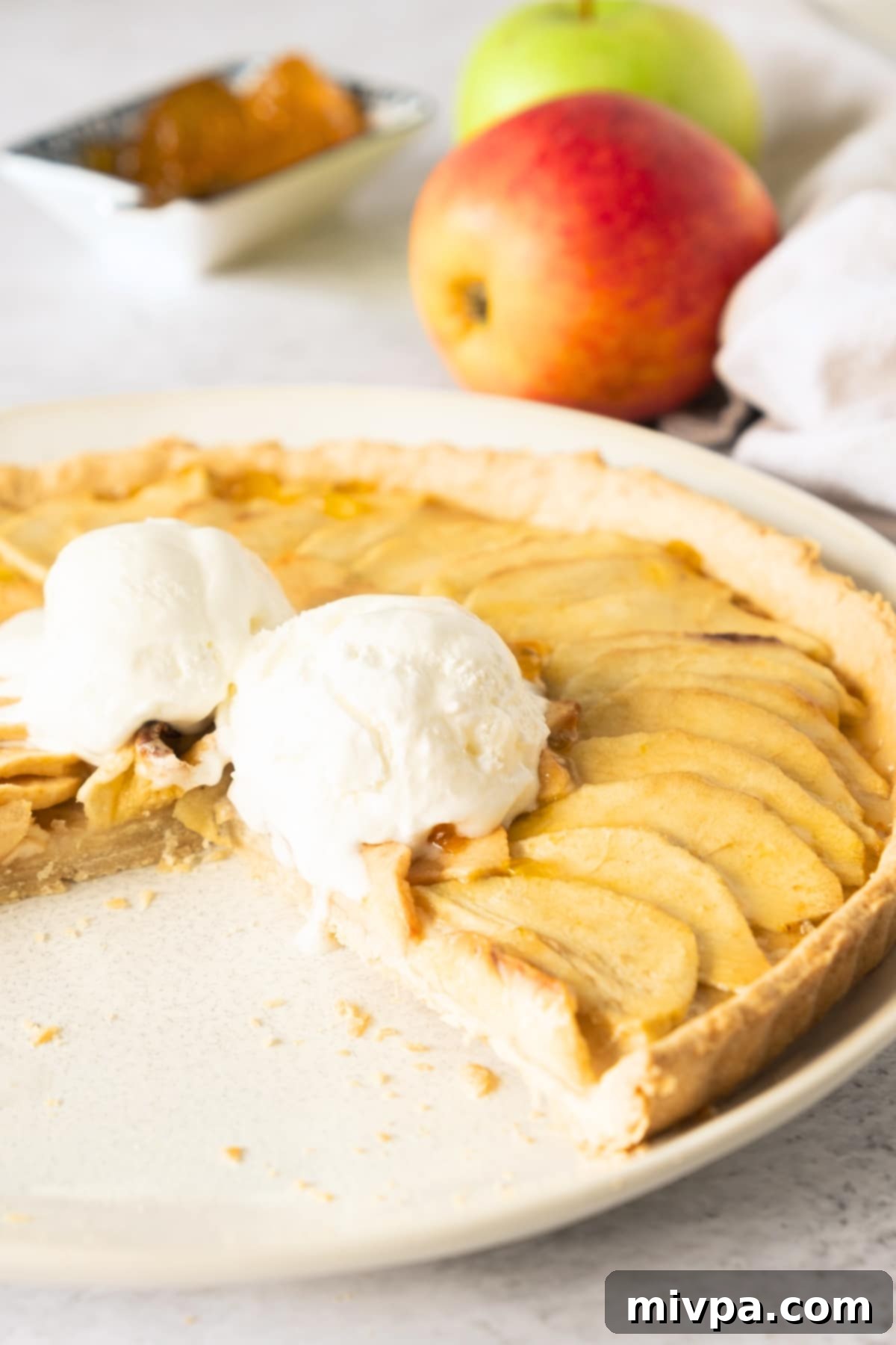 Gluten-Free Apple Tart (Dairy-Free) Half-eaten apple tart with ice cream on a plate.