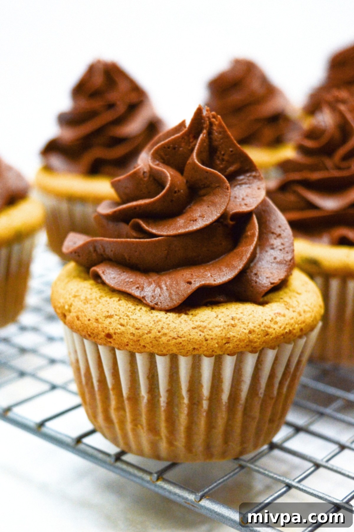 Gluten-Free Pumpkin Cupcakes (Dairy-Free) Gluten-free pumpkin cupcakes on wire rack, freshly baked and ready to be frosted.