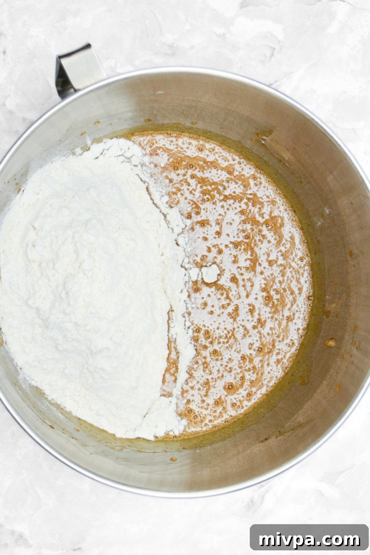 Gluten and Dairy-Free Pumpkin Spice Cupcakes 2 Metal bowl showing gluten-free flour being mixed into the pumpkin cupcake batter.