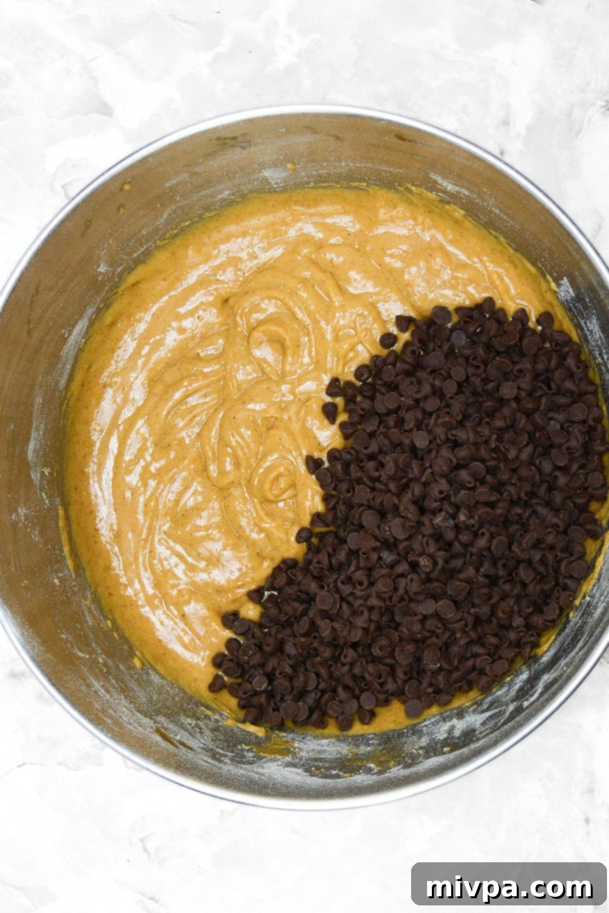 Gluten-Free Pumpkin Cupcakes (Dairy-Free) Pumpkin cupcake batter with mini chocolate chips folded in, ready for baking.