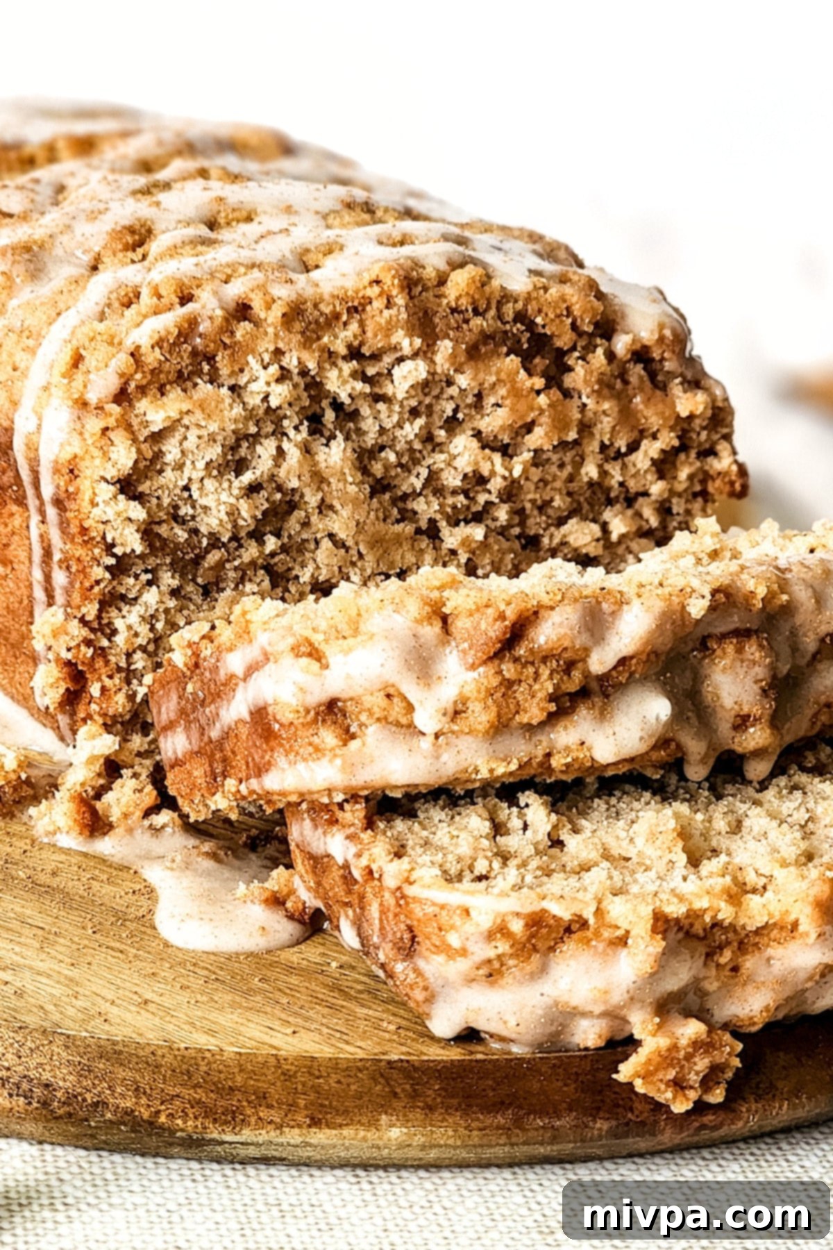 Gluten-Free Apple Bread Recipe (Dairy-Free, Vegan) Up close shot of sliced loaf of gluten-free apple bread with cinnamon glaze.