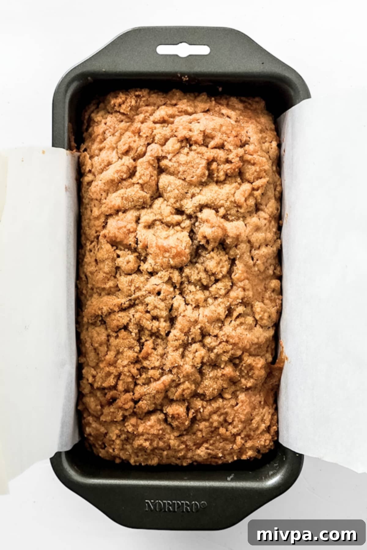 Gluten-Free Apple Bread Recipe (Vegan) Freshly baked loaf of gluten-free apple bread, golden brown, still in the loaf pan.