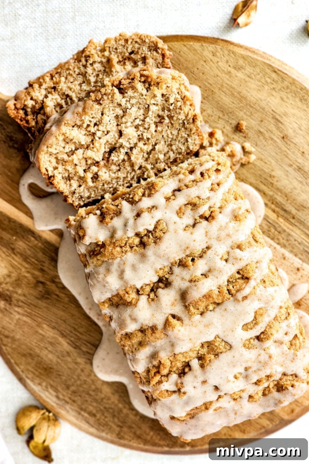 Gluten-Free Apple Cinnamon Bread (Vegan) Top down view of a freshly baked and sliced gluten-free apple loaf with crumble topping.