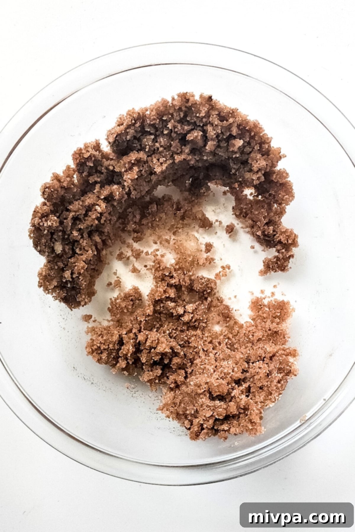 Gluten-Free Apple Spice Bread (Vegan) Sugar and cinnamon mixture with melted butter and vanilla extract in a glass bowl.