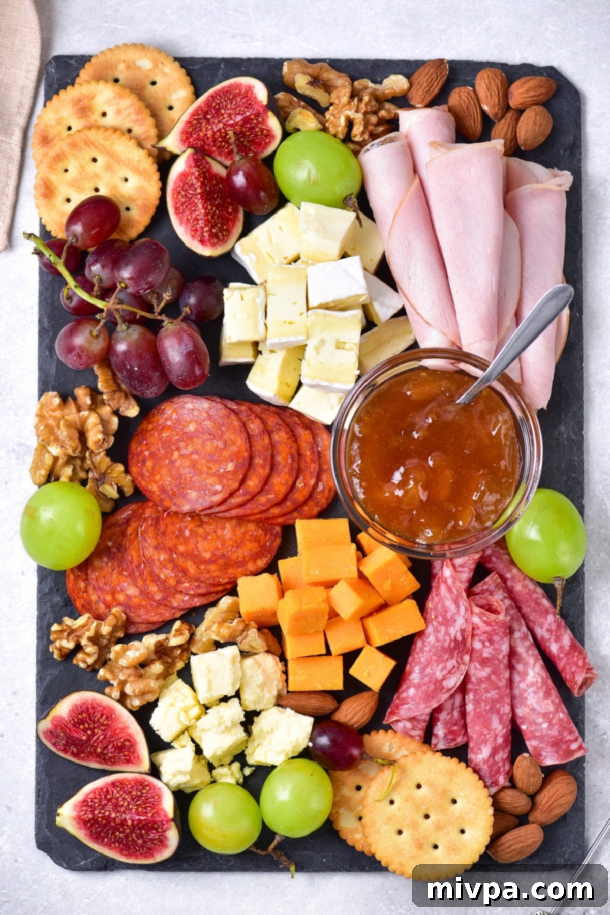 Top down view of charcuterie board on stone slate.