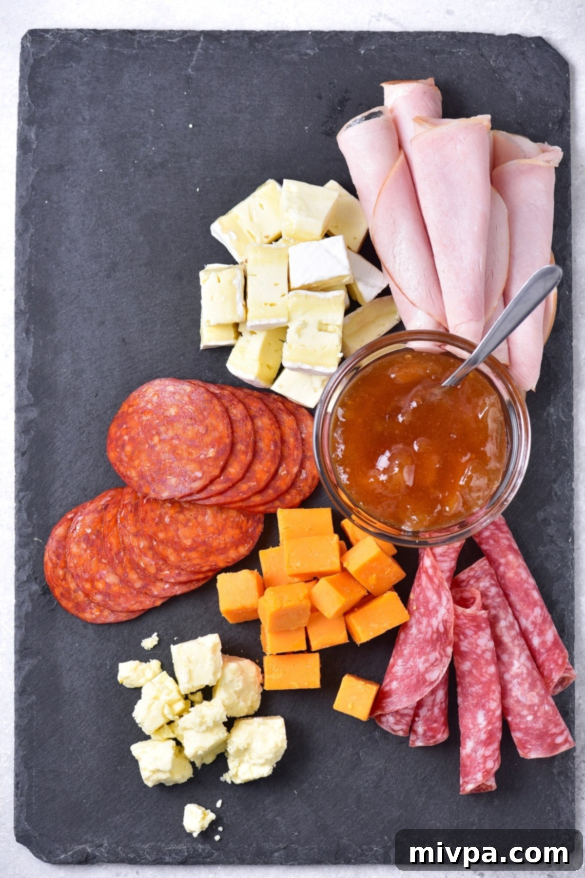 Cheeses and cured meats on platter.