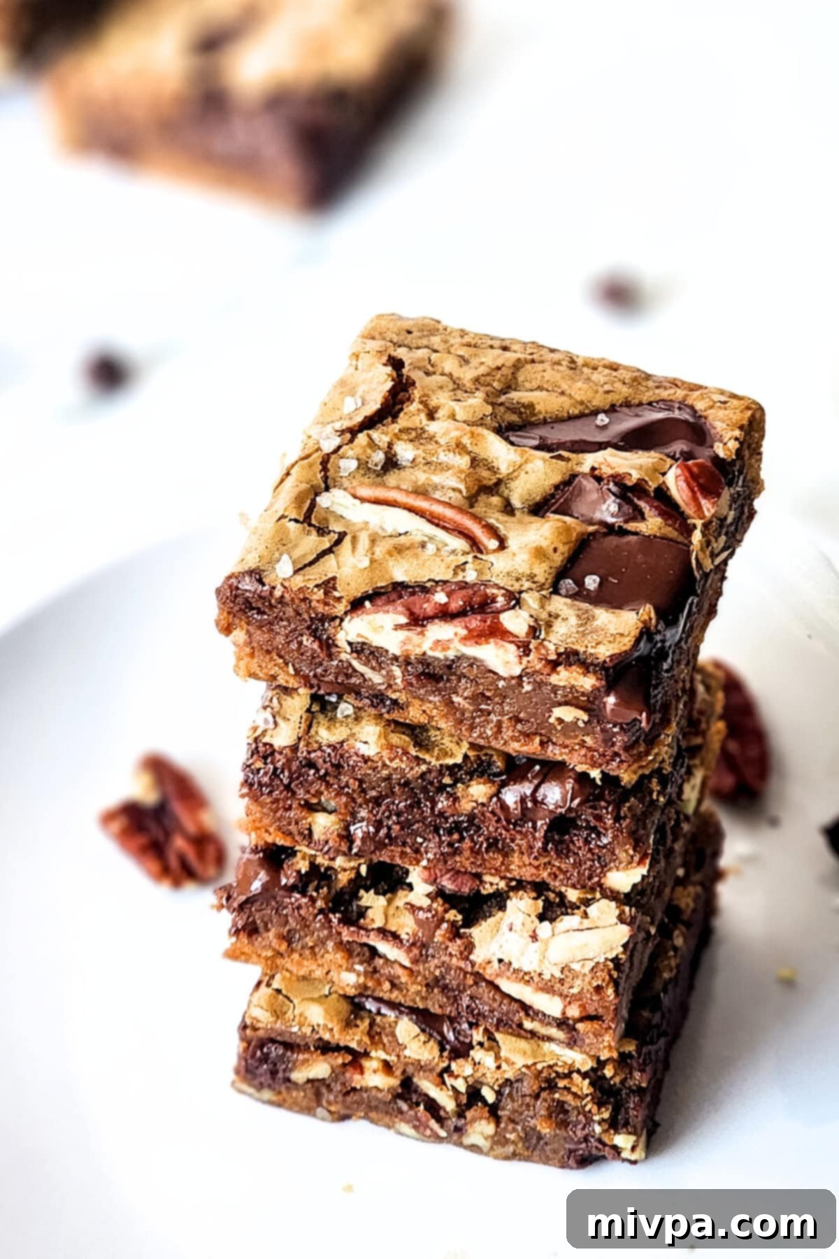 A beautifully arranged stack of pecan and chocolate blondies on a plate, ready to be served.