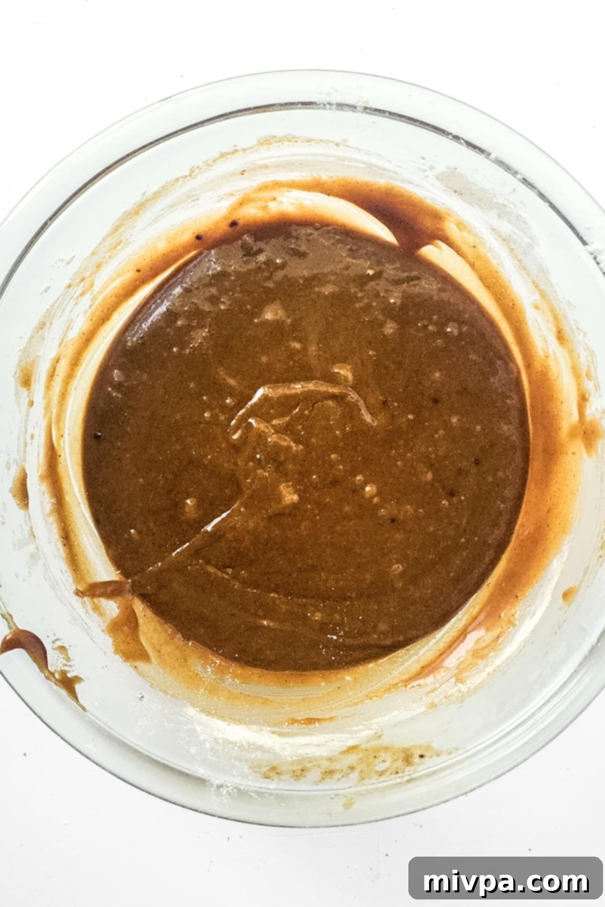A rich, thick blondie batter in a glass mixing bowl, perfectly mixed and ready for additions.