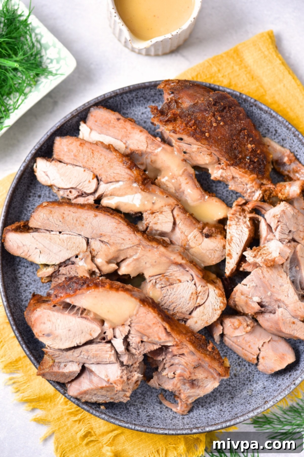 Oven Roasted Turkey Thighs (Gluten-Free, Dairy-Free) Sliced oven-roasted turkey thighs on a round plate, ready to be served.