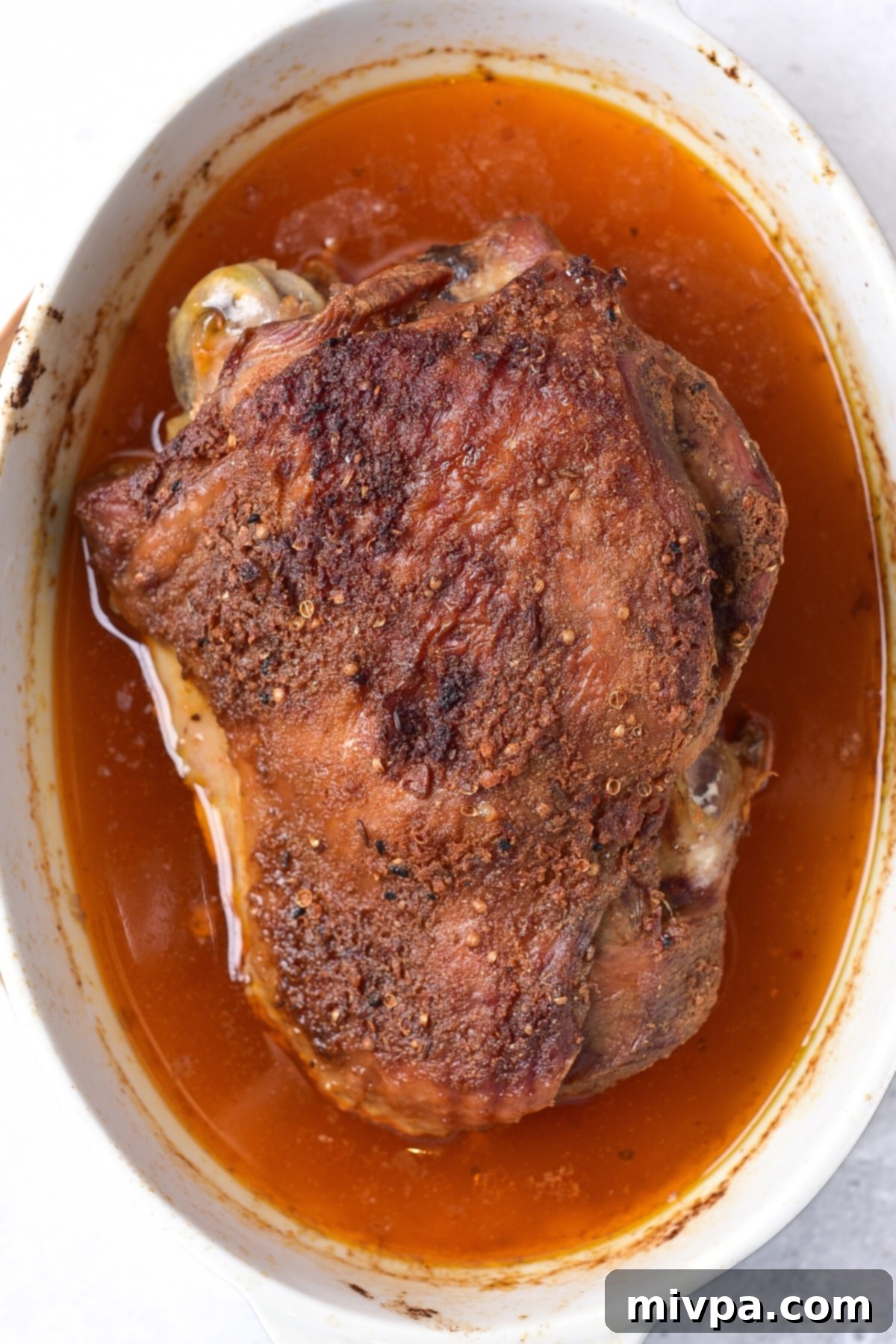 Oven Roasted Turkey Thighs (Gluten-Free, Dairy-Free) Freshly roasted turkey thigh in a baking dish, golden brown and ready.