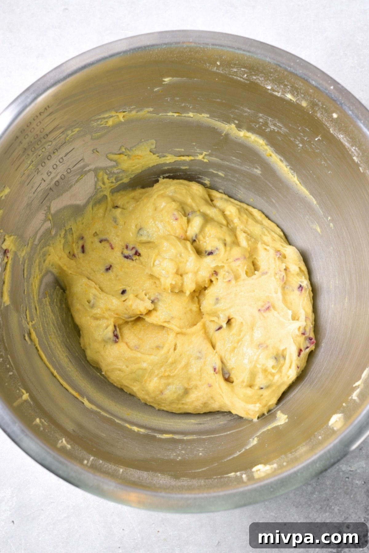 GF Cranberry Bliss Bars (Blondie Batter) Well-combined blondie batter with cranberries, orange zest, and white chocolate chips in a metal mixing bowl.