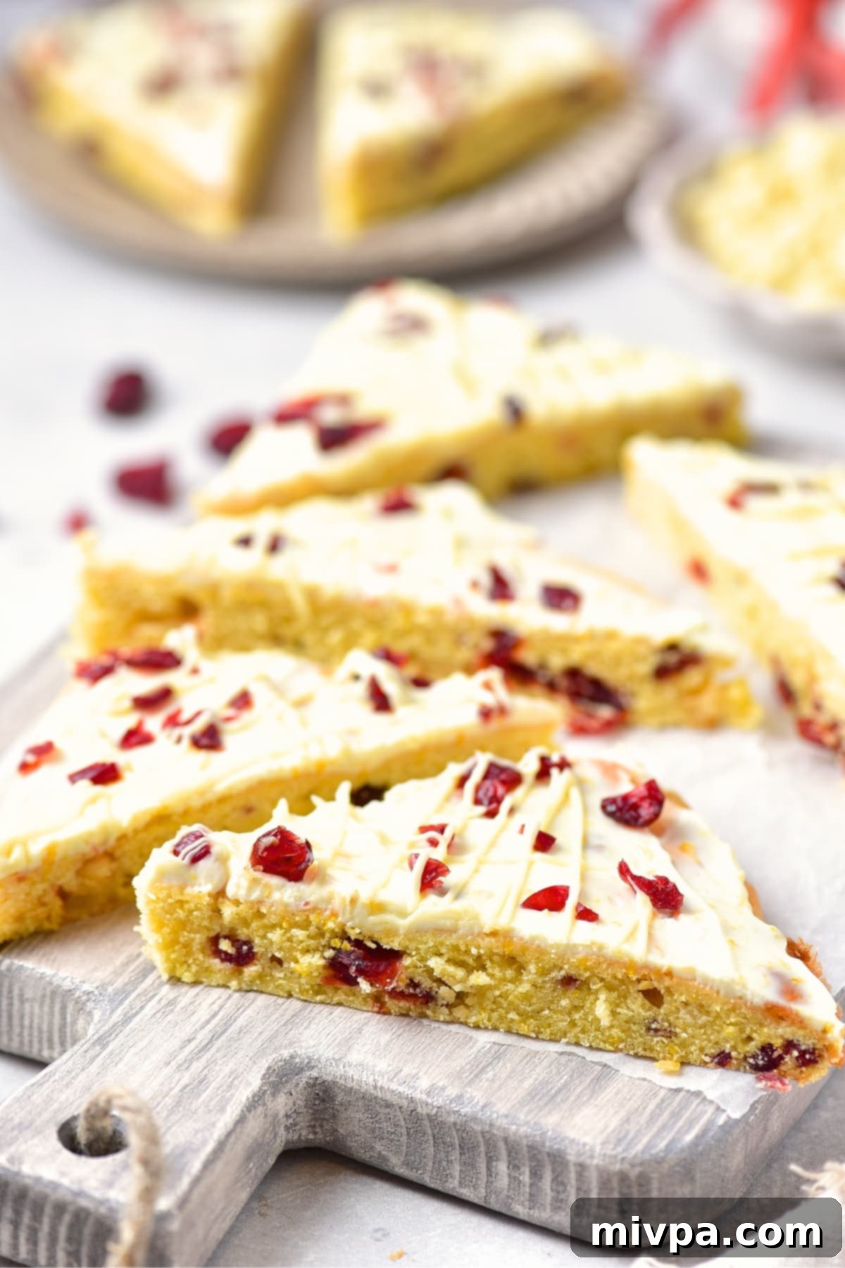 GF Cranberry Bliss Bars (Dairy-Free Serving) A close-up of a single gluten-free cranberry bliss bar on a wooden surface, highlighting its inviting appearance.
