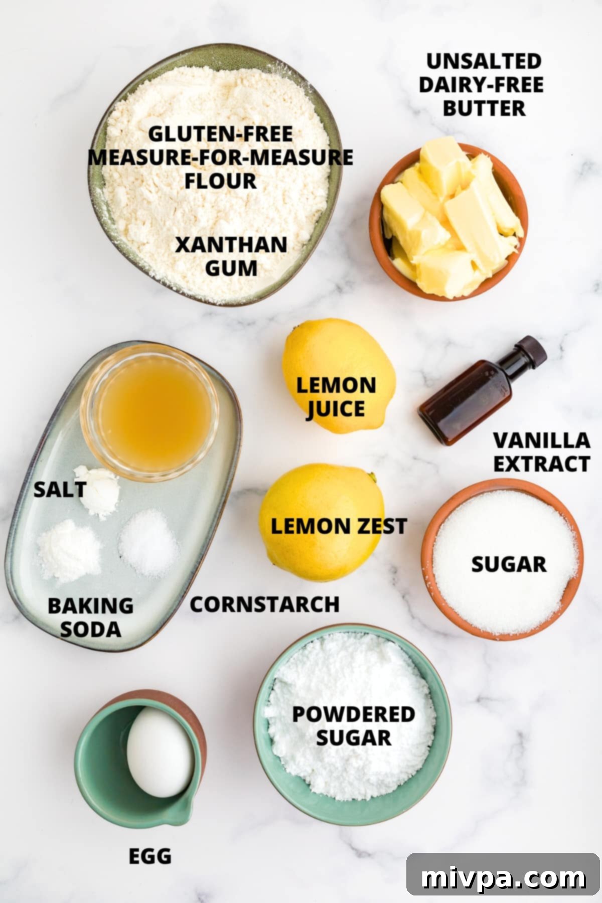 Ingredients for gluten-free lemon crinkle cookies recipe laid out on marble board.