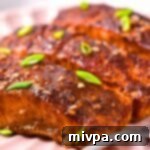 Delicious baked firecracker salmon fillet with a crispy skin, garnished with fresh herbs.