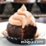 A close-up of a frosted gluten-free chocolate cupcake.