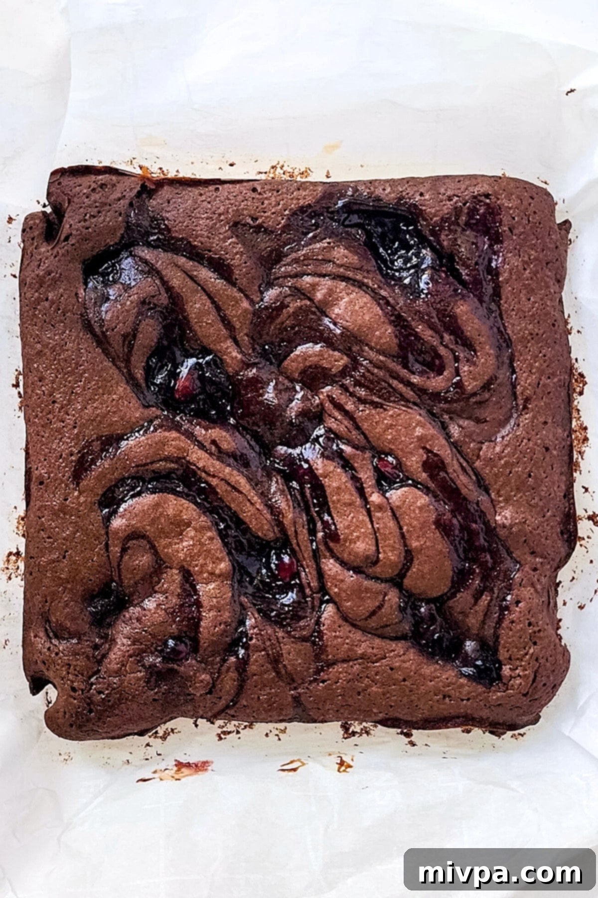Cherry Chocolate Brownies (Gluten-Free, Dairy-Free) A freshly baked Black Forest brownie cake, still in the pan, displaying its dark chocolate base and cherry swirls, warm from the oven.