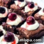 Simple Allergy Friendly Black Forest Brownies 3 A perfectly baked Black Forest brownie square, topped with cream and a cherry, ready for indulgence.