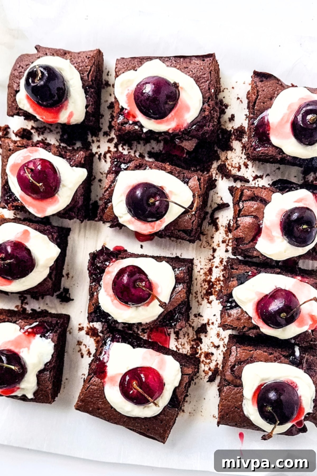 Black Forest Chocolate Brownies (Gluten-Free, Dairy-Free) An overhead shot showcasing freshly baked Black Forest Brownies on a piece of parchment paper, highlighting their rich color and inviting texture.