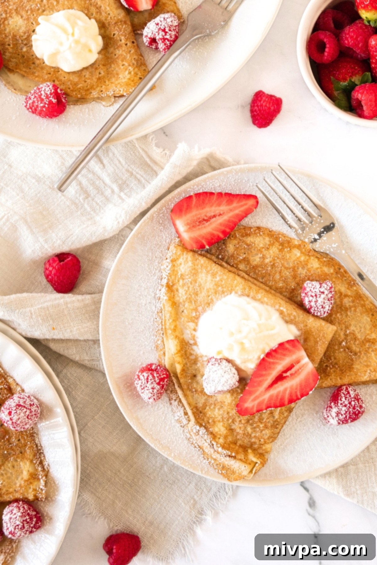Gluten-Free Crepes (Dairy-Free) Top down view of three plates of gluten-free crepes and berries.