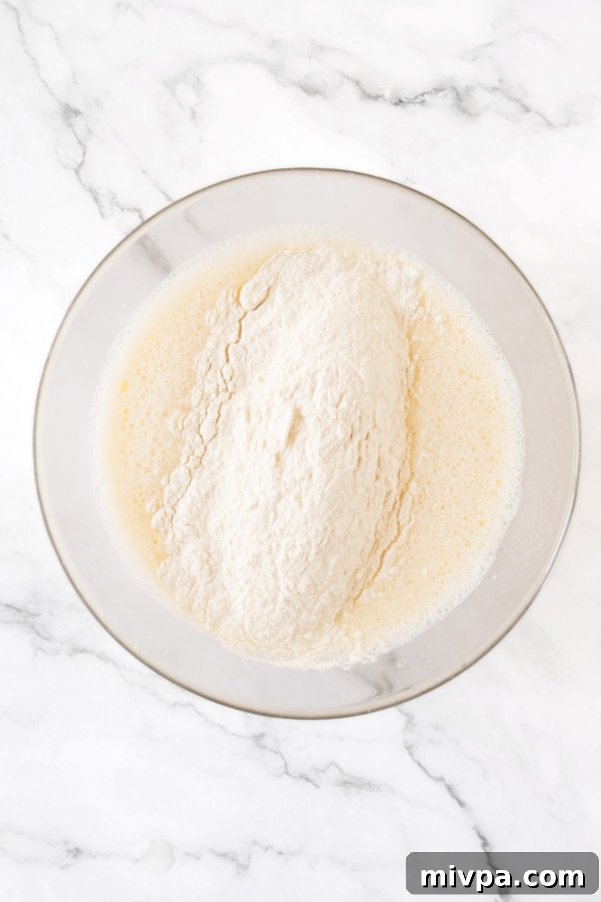 Gluten-Free Crepes (Dairy-Free) Flour mixture on top of liquid mixture in bowl.