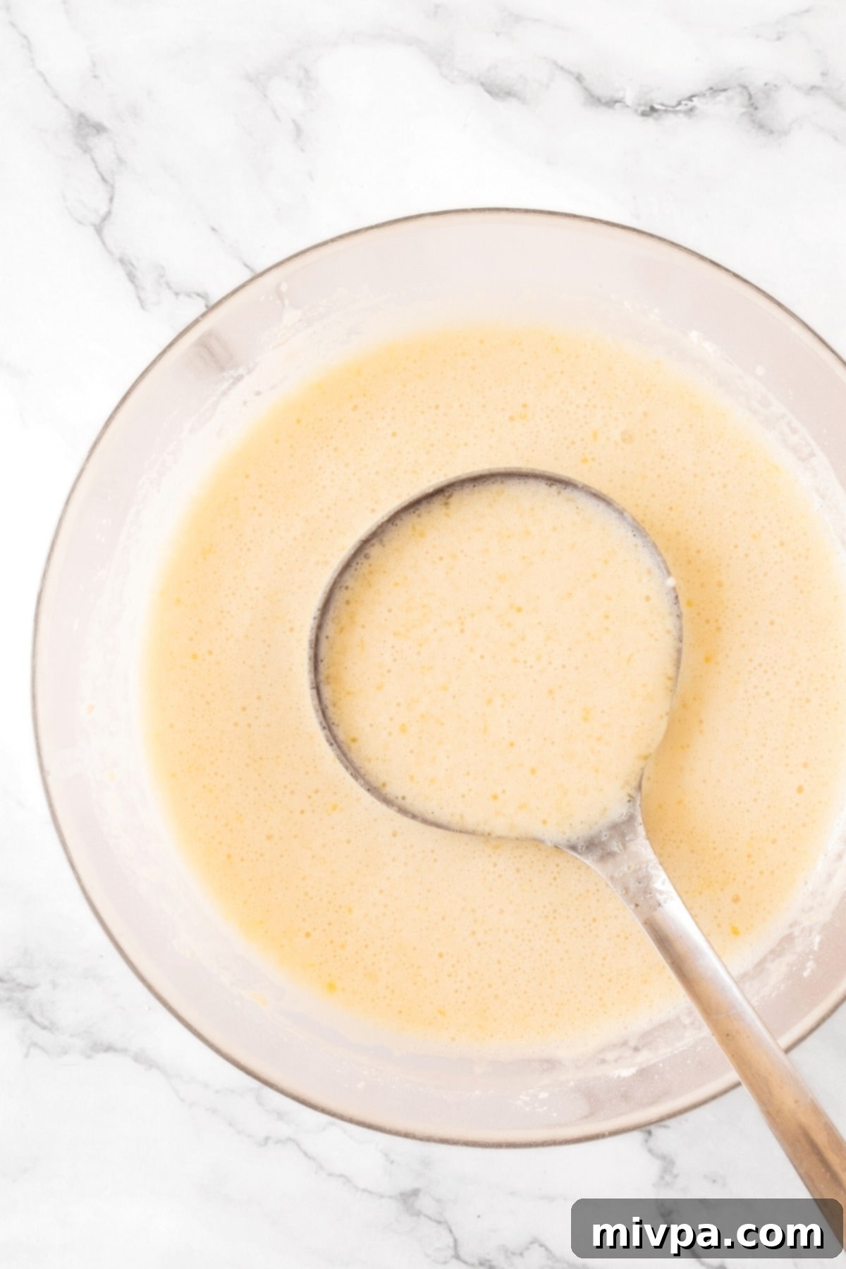 Recipe for Gluten-Free Crepes (Dairy-Free) Scooping a ladleful of gluten-free crepe batter.