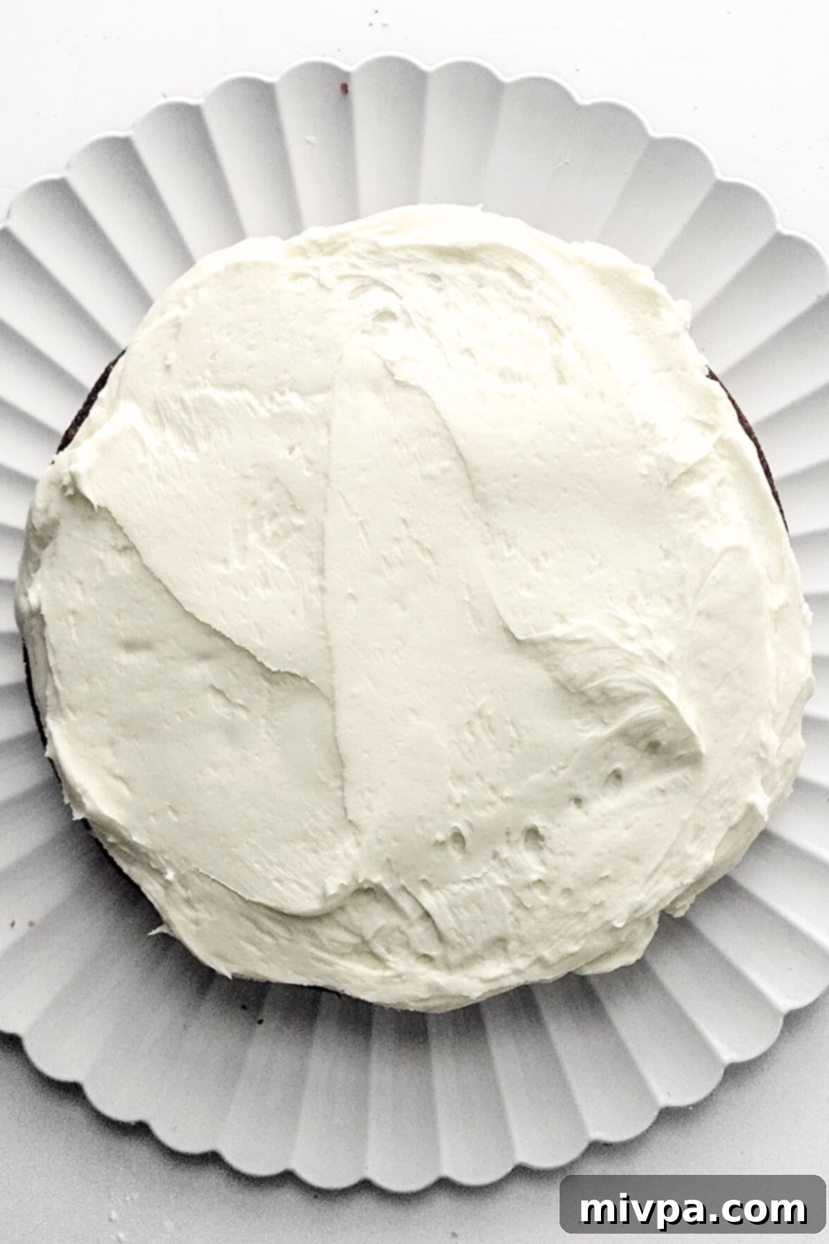 Carrot Cake with Cream Cheese Frosting Cream cheese frosting spread over carrot cake.