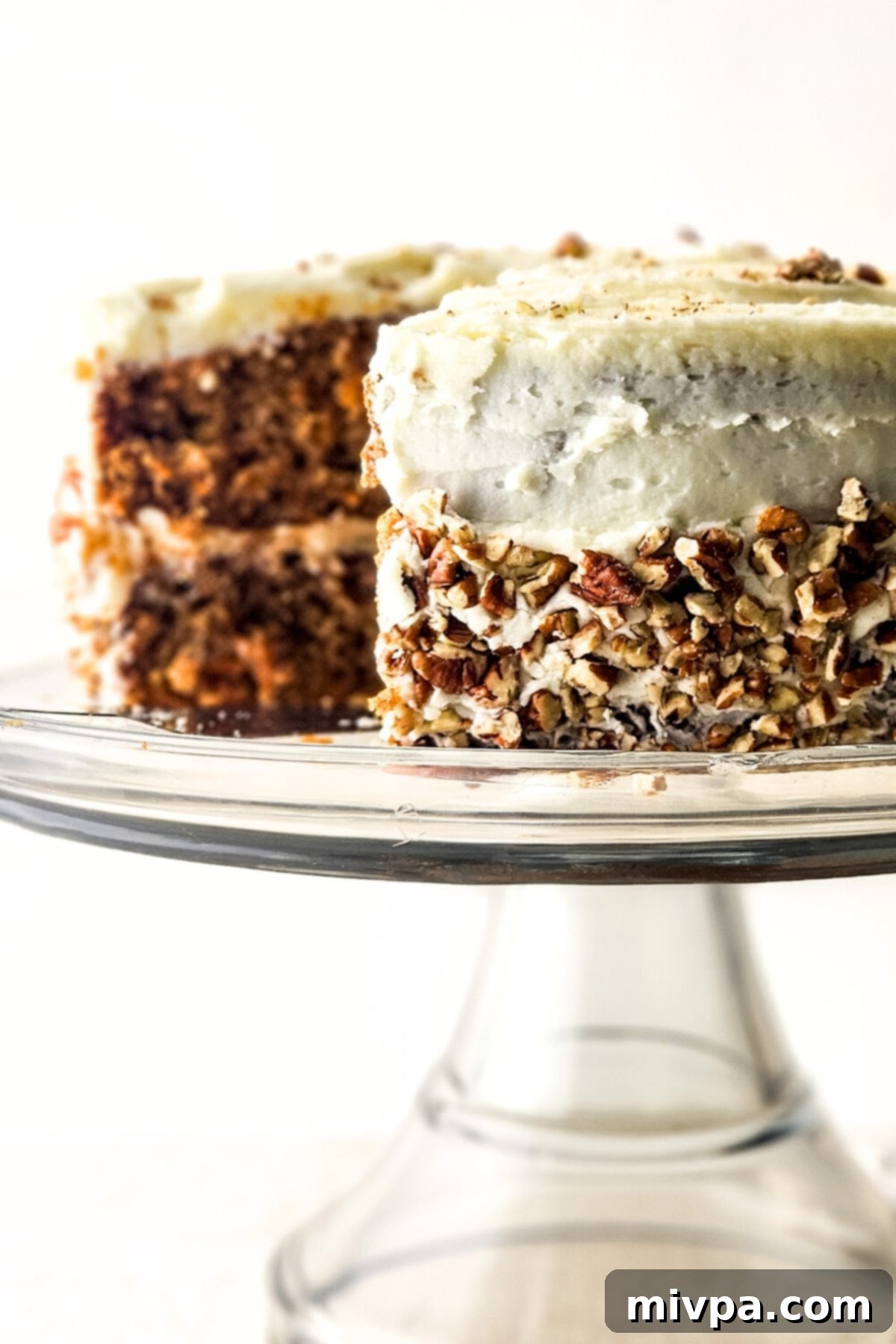 Gluten-Free Healthy Carrot Cake Half-eaten carrot cake on cake stand.